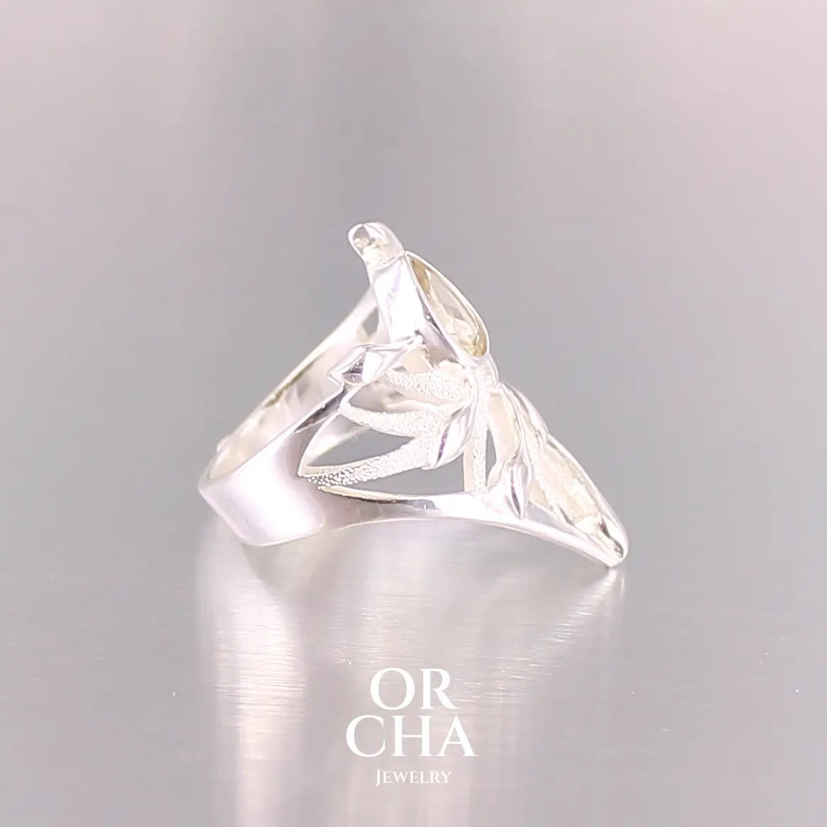 Pofil d'une grande Bague topaze impériale et argent massif illustrant un feuillage tropicale. Bijou pour femme sertie d'une Topaze impériale de couleur jaune pâle doré, pierre facettée en forme de poire. Pierre très lumineuse et propre à l'oeil. Bijoux unique, éthique et durable présenté dans un coffret de notre marque, prêt à offrir. Livraison offerte, certificat d'authenticité, service client.