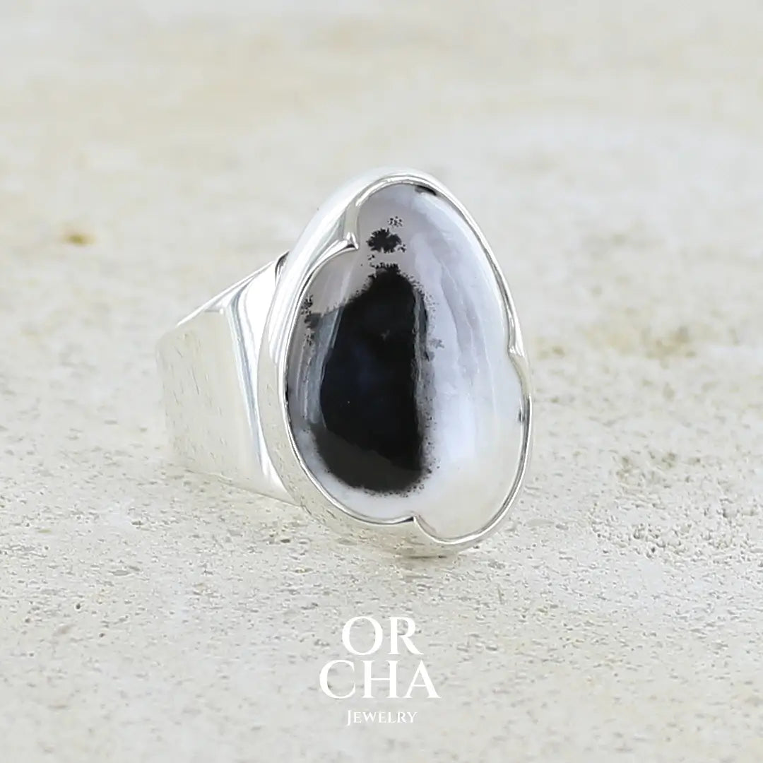 Bague pour femme en argent massif sertie d'un cabochon d'agate dendritique de couleur blanc pur et noir. Pierre opaque translucide à inclusions paysages de dendrites de manganèse noires contrastées. Bijou unique réalisée en taille 56 par Orchajewelry