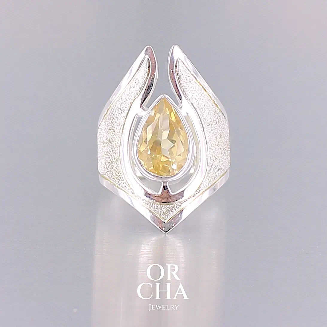 Grande bague contemporaine pour femme en argent massif sertie d'une Citrine. Pierre facettée en forme de goutte de qualité transparente, propre à l'oeil. Pierre naturelle de couleur jaune or lumineux. Bijoux unique, éthique et durable présenté dans un coffret de notre marque, prêt à offrir. Livraison offerte, certificat d'authenticité, service client.