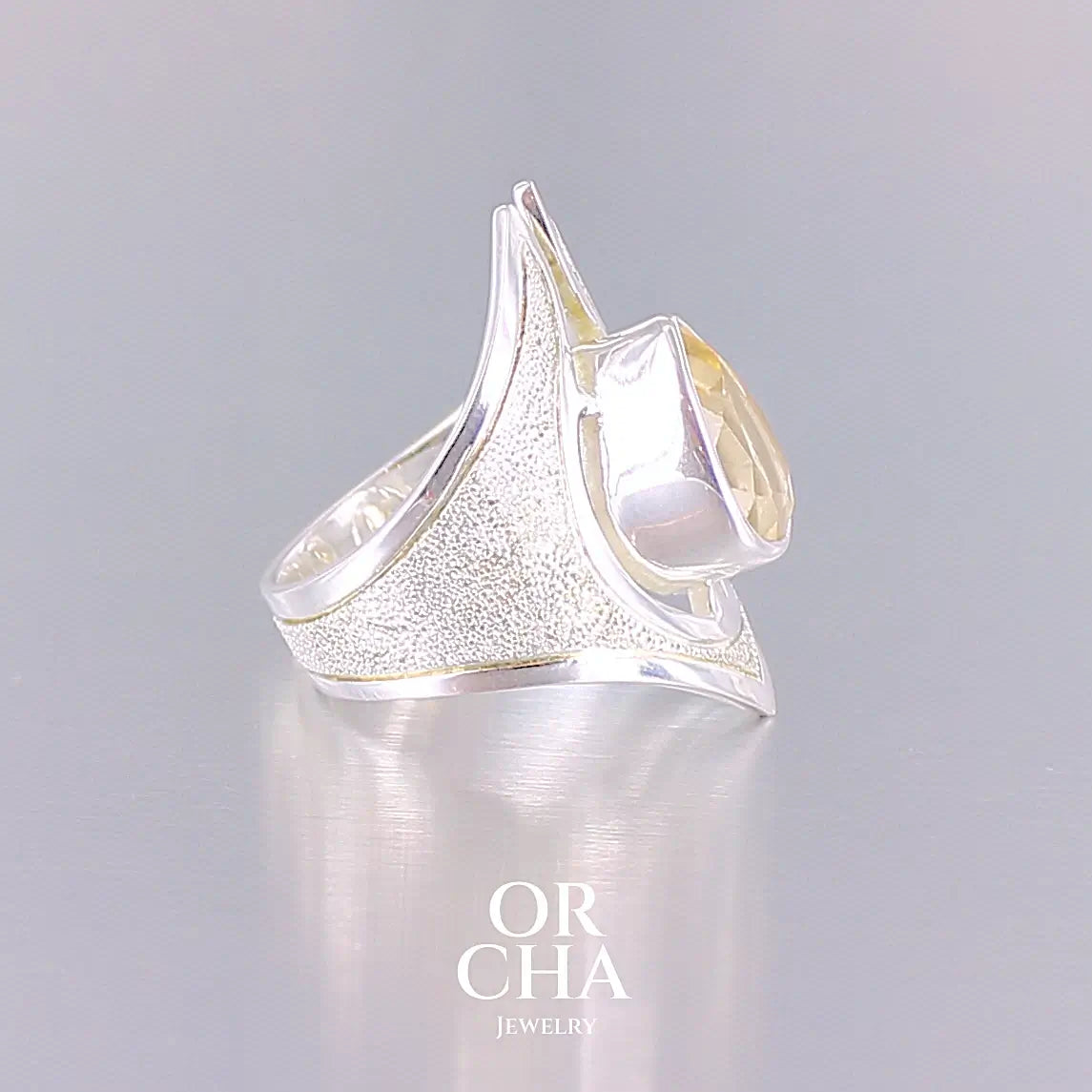 profil d'une Grande bague contemporaine pour femme en argent massif sertie d'une Citrine. Pierre facettée en forme de goutte de qualité transparente, propre à l'oeil. Pierre naturelle de couleur jaune or lumineux. Bijoux unique, éthique et durable présenté dans un coffret de notre marque, prêt à offrir. Livraison offerte, certificat d'authenticité, service client.