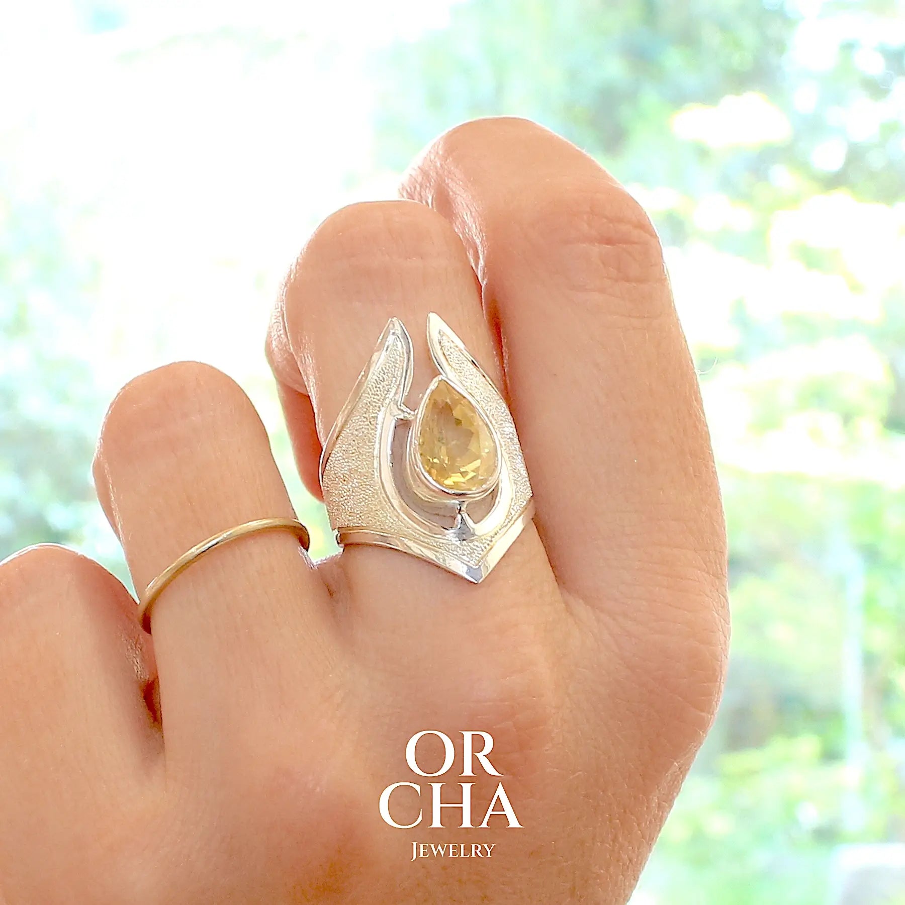 Grande bague contemporaine pour femme en argent massif sertie d'une Citrine. Pierre facettée en forme de goutte de qualité transparente, propre à l'oeil. Pierre naturelle de couleur jaune or lumineux. Bijoux unique, éthique et durable présenté dans un coffret de notre marque, prêt à offrir. Livraison offerte, certificat d'authenticité, service client.