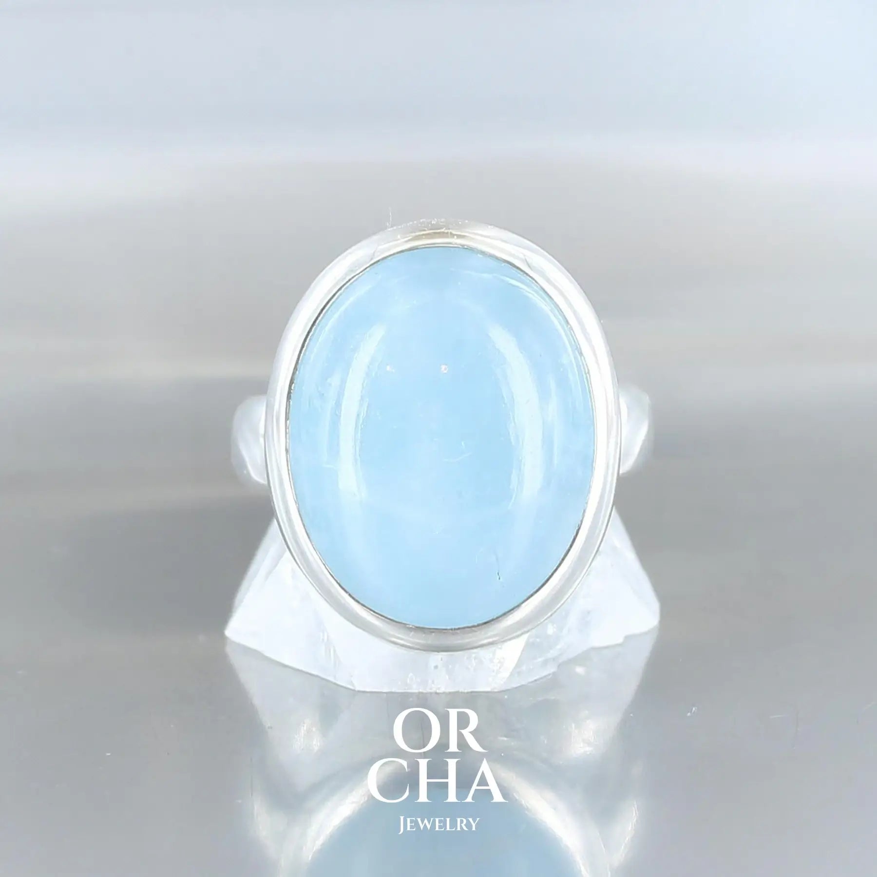 Bague pour femme en argent massif sertie d'un cabochon de forme oval d'Aigue-marine. Cette bague est une pièce unique fabriquée de manière traditionnel à la main en taille 54. Bijoux éthique et durable présenté dans une boite de notre marque, prêt à offrir.