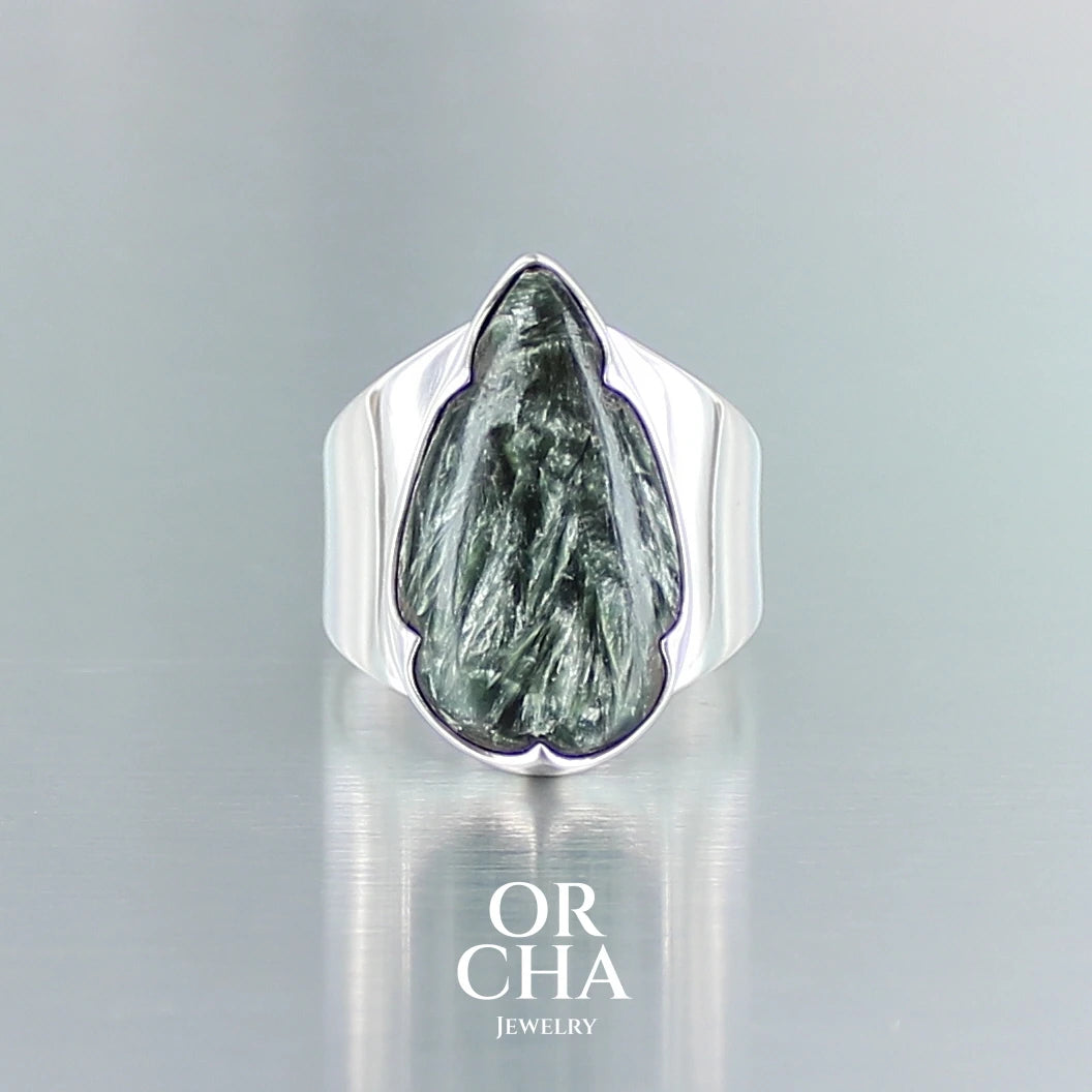 Bague pour femme en argent massif sertie d'une Seraphinite. Pierre cabochon en forme de goutte de qualité opaque. Pierre naturelle de couleur vert kaki à chatoyance plus clair. Bague réalisée en taille 58. Bijoux unique, éthique et durable présenté dans un coffret de notre marque, prêt à offrir. Livraison offerte, certificat d'authenticité, service client.