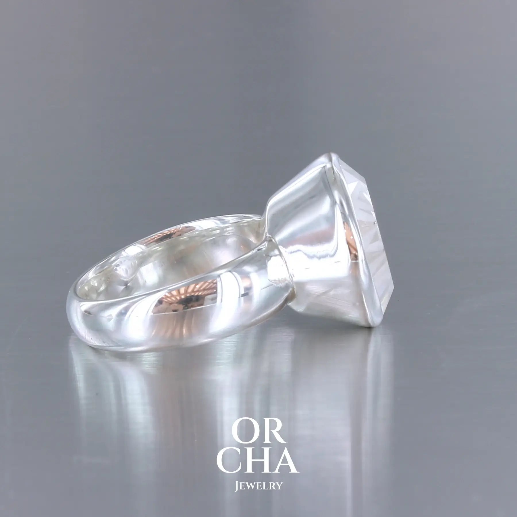 Bague cocktail pour femme en argent massif sertie d'un Cristal de roche gravé d'une fleur de vie. Pierre facettée de forme carrée de qualité transparente, propre à l'oeil. Pierre naturelle incolore et blanche sur les parties gravées. Bague réalisée en taille 60. Bijoux unique, éthique et durable présenté dans un coffret de notre marque, prêt à offrir. Livraison offerte, certificat d'authenticité, service client.