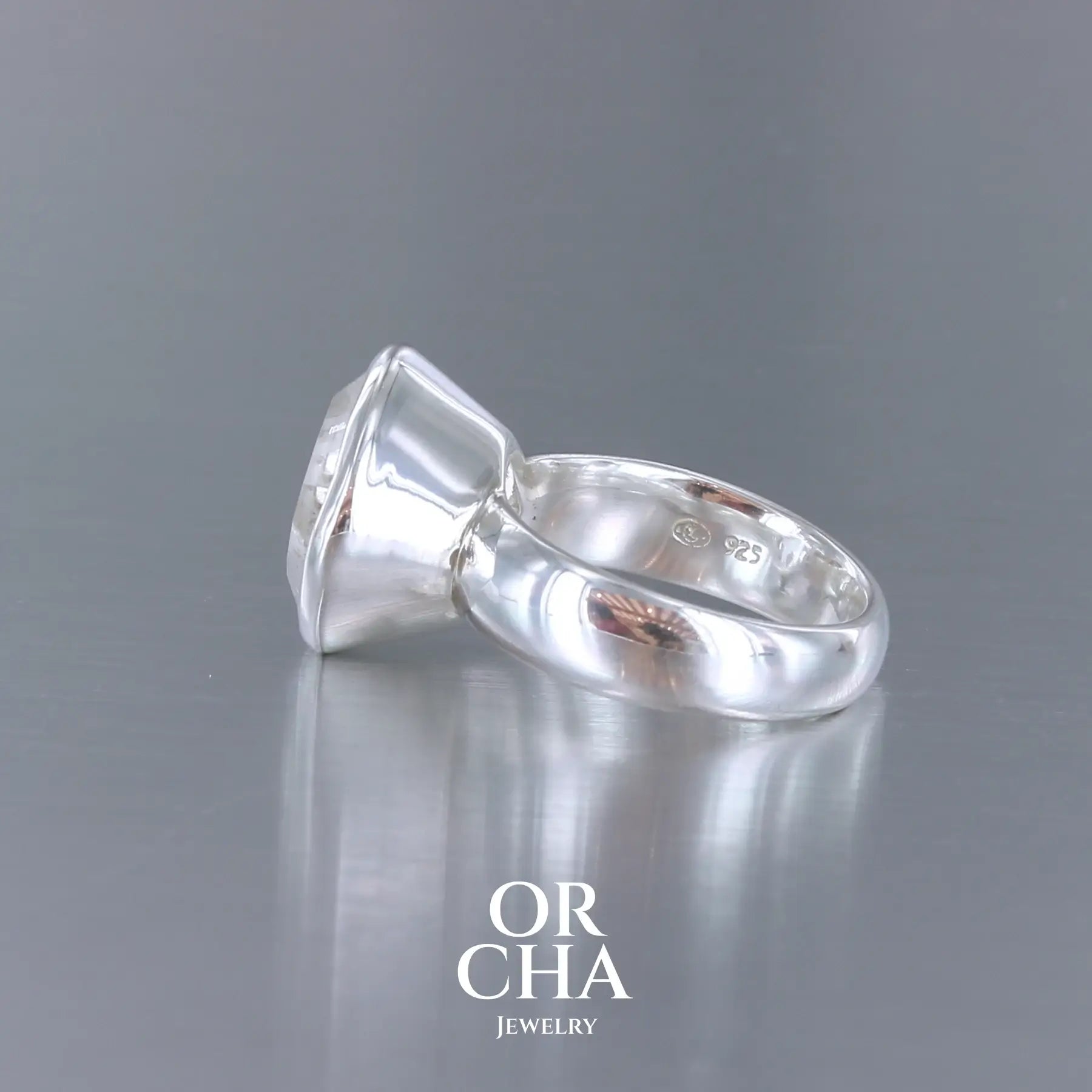 Bague cocktail pour femme en argent massif sertie d'un Cristal de roche gravé d'une fleur de vie. Pierre facettée de forme carrée de qualité transparente, propre à l'oeil. Pierre naturelle incolore et blanche sur les parties gravées. Bague réalisée en taille 52 ou 54. Bijoux unique, éthique et durable présenté dans un coffret de notre marque, prêt à offrir. Livraison offerte, certificat d'authenticité, service client.