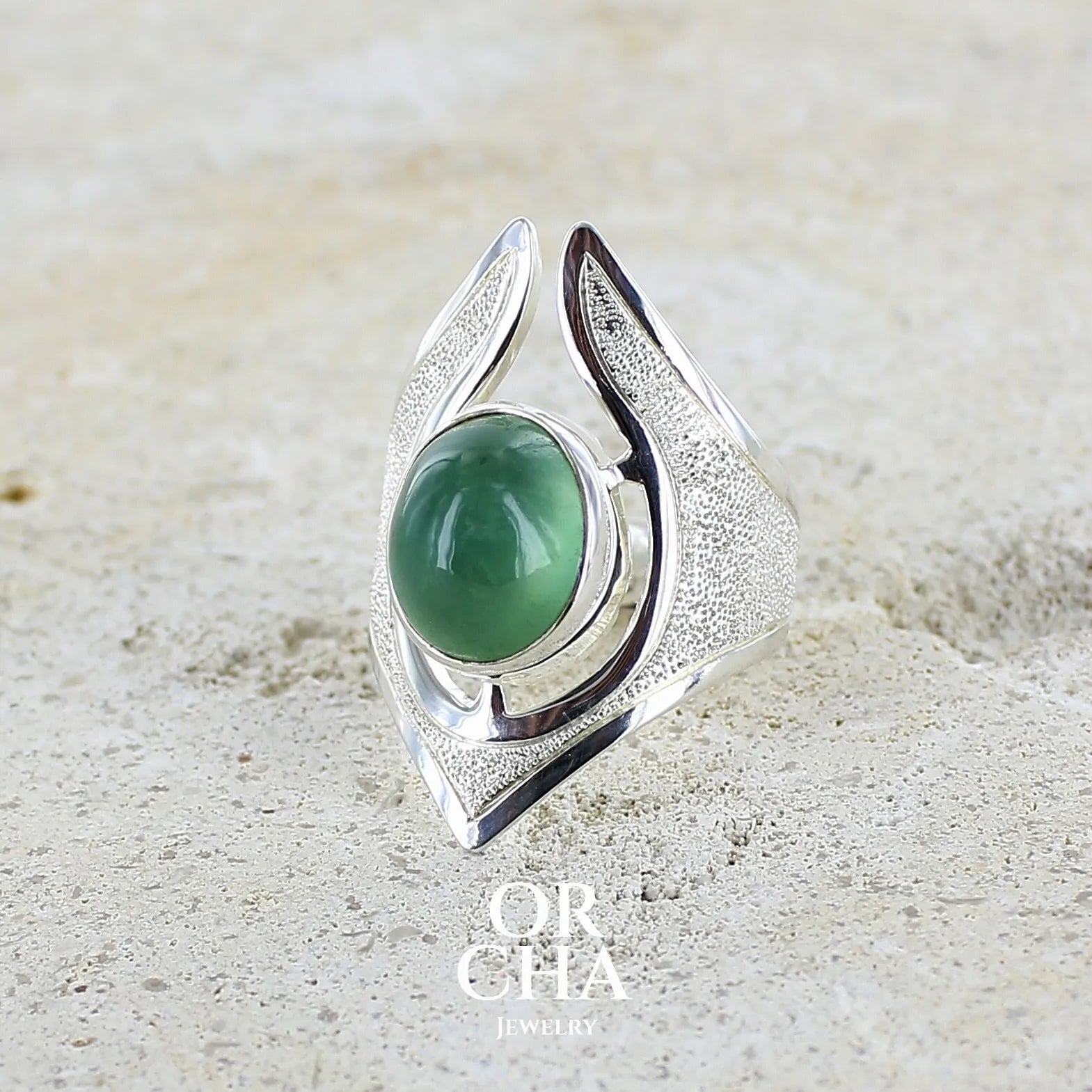Grande bague pour femme en argent massif sertie d'une préhnite de couleur verte jaune clair, Pierre taillée en cabochon en forme de goutte. Pierre gemme de qualité transparente à inclusions. Bijoux unique réalisé en taille 59 par Orchajewelry.
