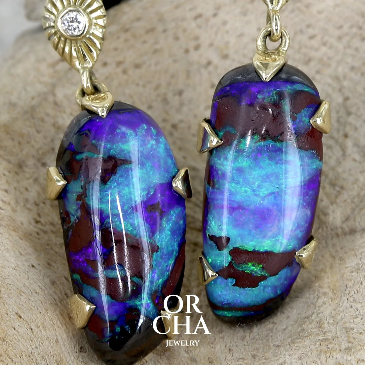 Boucles d'oreilles pendantes en or 18k serties d'opales aux feux multicolores turquoises et bleus violets, ainsi que de diamants. Pierres cabochons de qualité opaque. Bijoux uniques par Orchajewelry.
