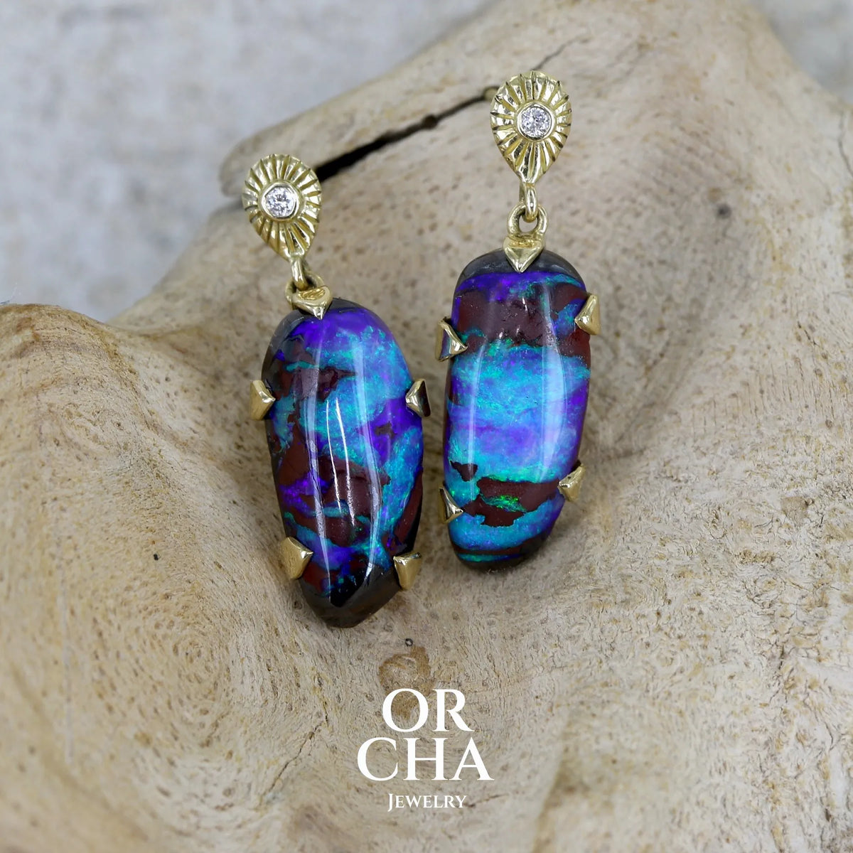 Boucles d'oreilles pendantes en or 18k serties d'opales aux feux multicolores turquoises et bleus violets, ainsi que de diamants. Pierres cabochons de qualité opaque. Bijoux uniques par Orchajewelry.