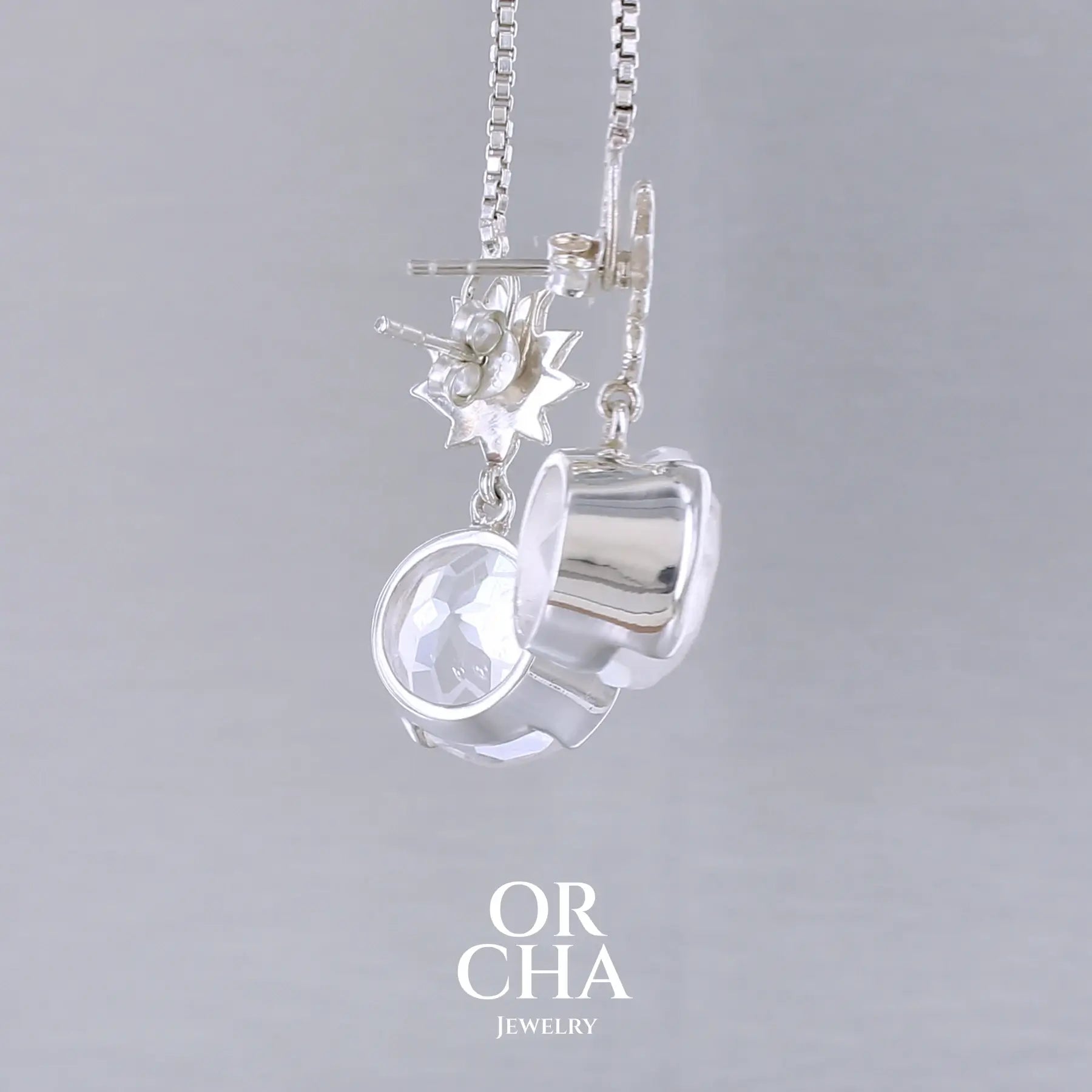 Boucles d'oreilles pour femme en argent massif sertie de Cristals de roche gravés de fleurs de vie. Pierres facettées de forme ronde de qualités transparentes, propre à l'oeil. Pierre naturelle incolore et blanche sur les parties gravées. Le clou des boucles représente un lotus. Bijoux unique, éthique et durable présenté dans un coffret de notre marque, prêt à offrir. Livraison offerte, certificat d'authenticité, service client.