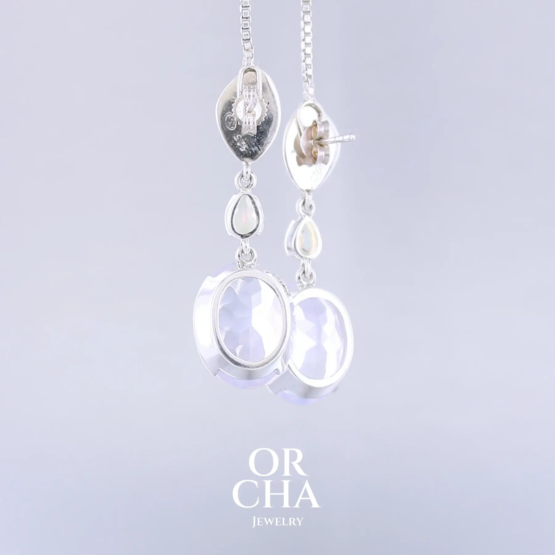 Boucles d'oreilles pour femme en argent massif sertie de Quartz lavandes et d'opales d'Éthiopie. Pierres facettées de forme ovales et de gouttes de qualités transparentes, propre à l'oeil. Pierres naturelles de couleurs violettes pastel teintées de rose avec des reflets opalescents et multicolores pour les opales . Bijoux unique, éthique et durable présenté dans un coffret de notre marque, prêt à offrir. Livraison offerte, certificat d'authenticité, service client.