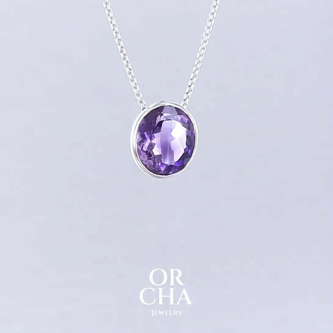 Collier solitaire pour femme en argent massif sertie d'une Améthyste. Pierre facettée de forme ovale de qualité transparente, propre à l'oeil. Pierre naturelle de couleur violet foncé à plus clair. Pendentif monté sur une chaine en argent sterling de type maille vénitienne de 1,3 mm d'épaisseur et de 40 cm de longueur. Bijoux unique, éthique et durable présenté dans un coffret de notre marque, prêt à offrir. Livraison offerte, certificat d'authenticité, service client.