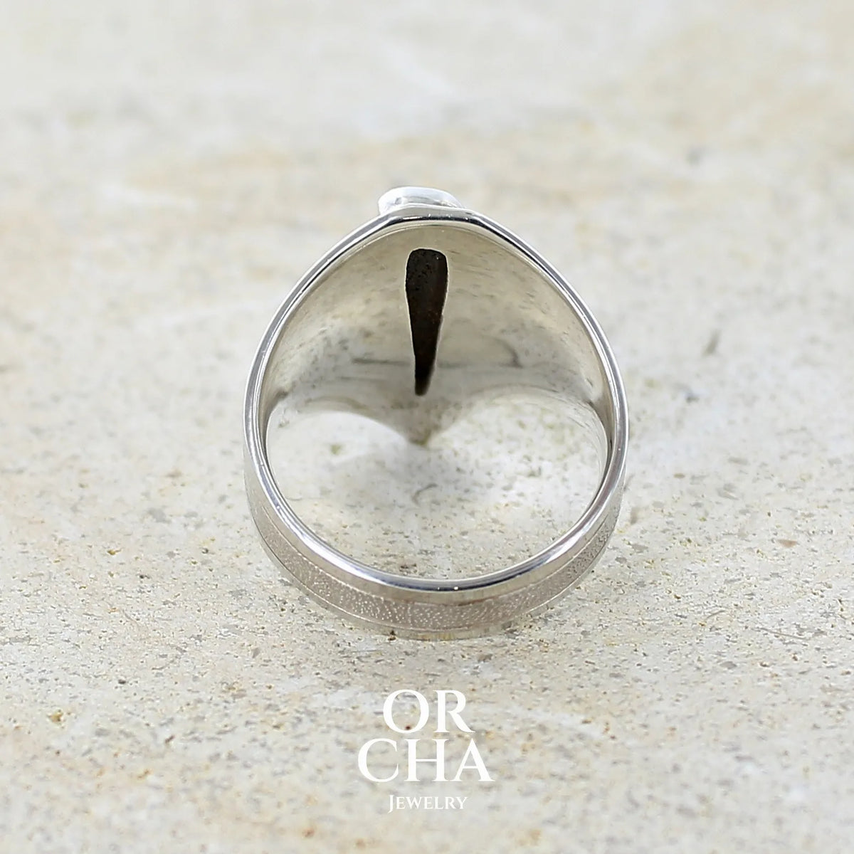 Vue de dos d'une bague pour femme en argent massif 925 sertie d'une opale boulder aux feux multicolores. Cabochon d'opale massive naturelle taillée en forme d'aile. Pierre de qualité opaque. Bijoux unique réalisé en taille 57 par Orcha Jewelry.
