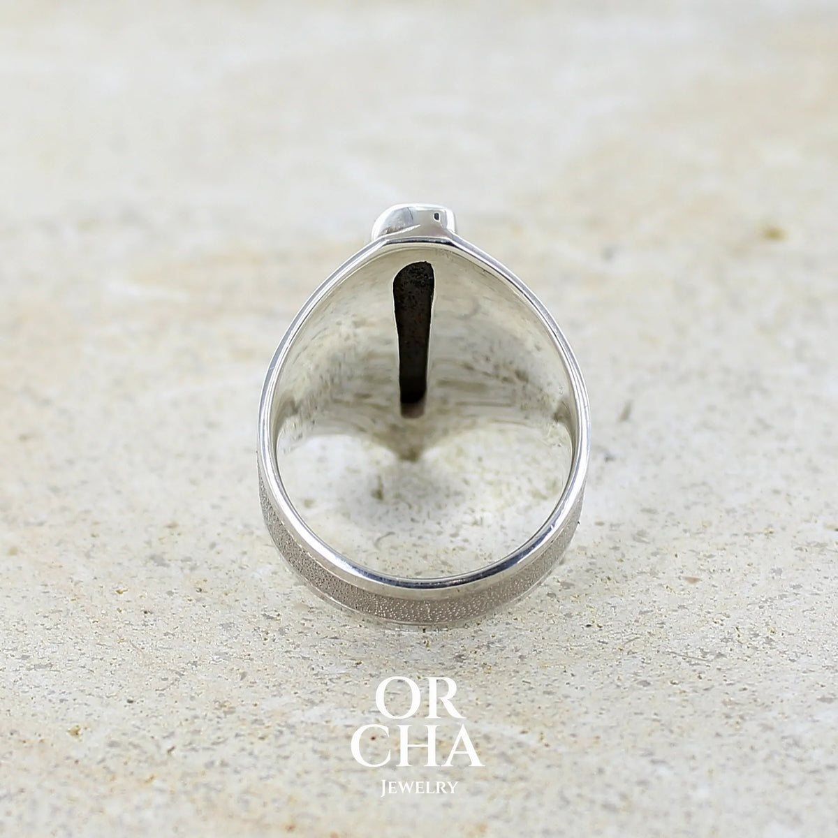 Vue de dos d'une bague plastron pour femme en argent massif 925 sertie d'une opale boulder aux feux multicolores. Cabochon d'opale massive naturelle, de qualité opaque. Bijoux unique réalisé en taille 59 par Orcha Jewelry.