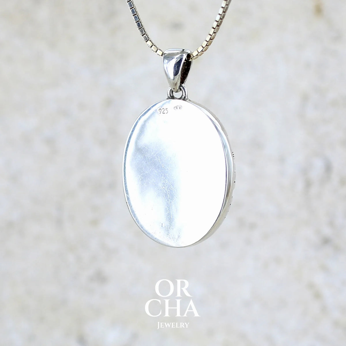 Vue de dos d'un pendentif steam punk pour homme en argent massif sertie d'une tranche ovale d'agate dendritique de couleur gris et noir, orné de mécanismes de montre. Pierre translucide à inclusions de type tâches d'encre de dendrites de manganèse noires contrastées. Bijou unique réalisé par Orchajewelry