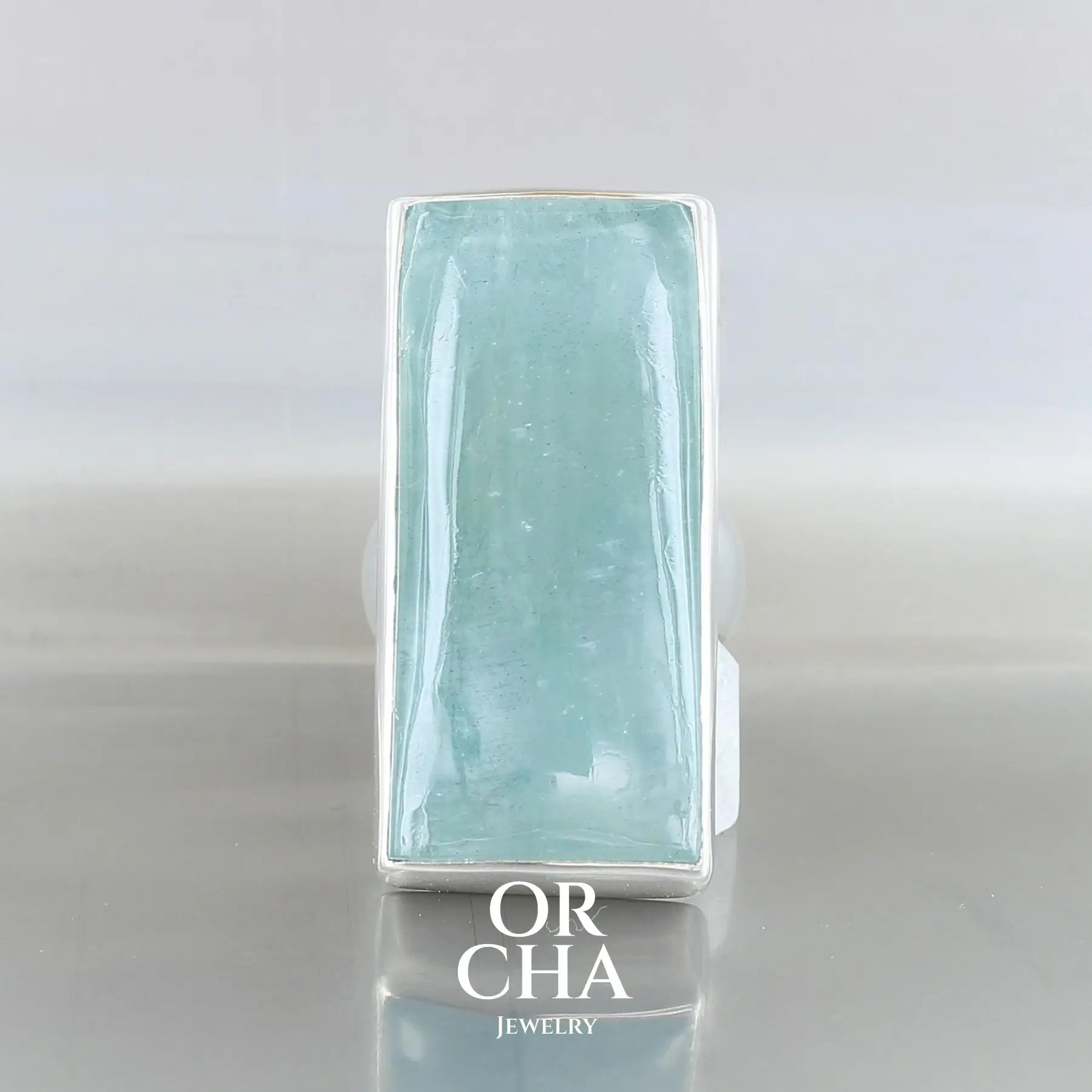 Grande bague de créateur en argent sterling 925 sertie d’une Aigue-marine, pierre naturelle de couleur bleu foncé grisé. Cette bague est fabriquée entièrement à la main, en taille 59. Un bijou unique, éthique et durable présenté dans un coffret de notre marque, prêt à offrir.