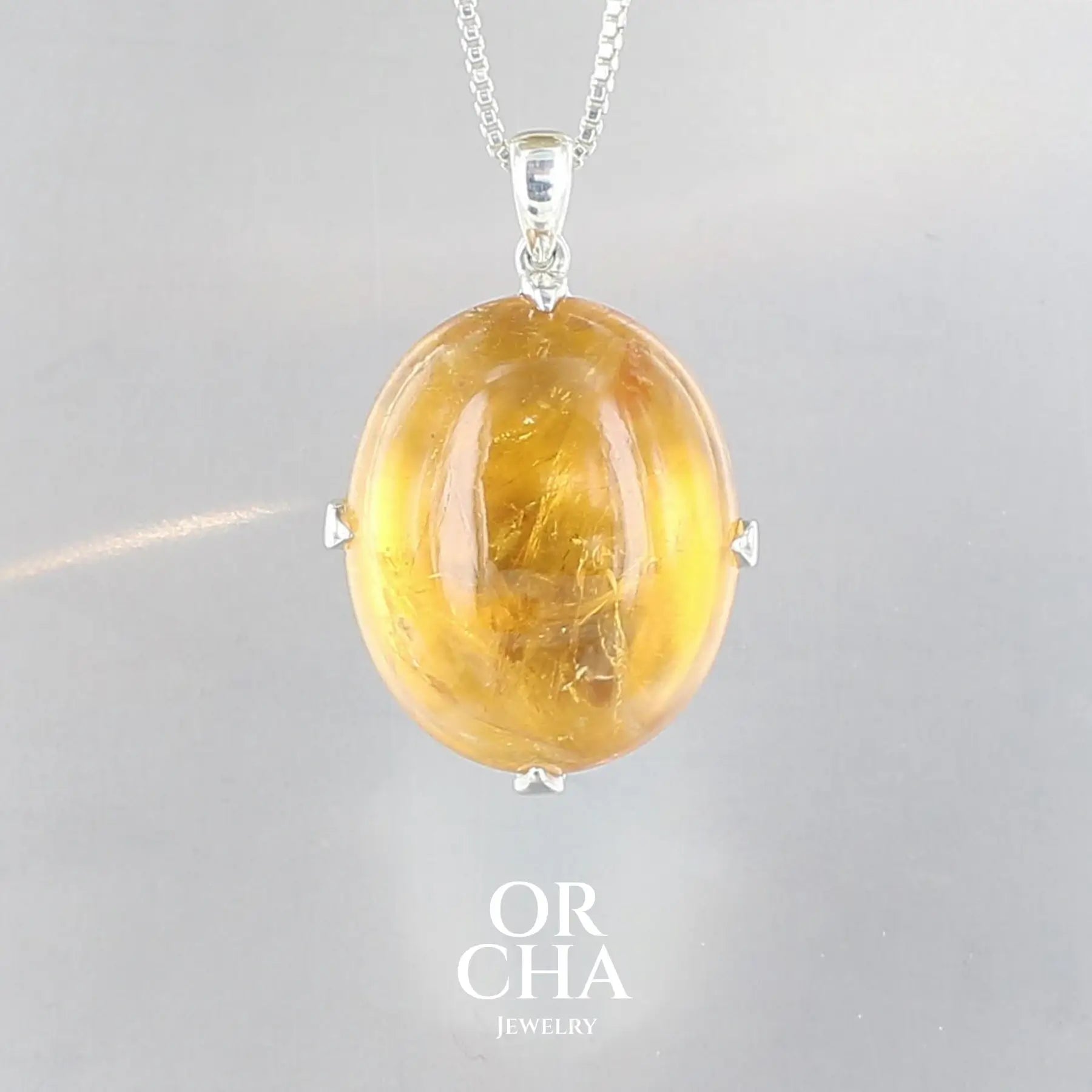 pendentif pour femme en argent massif serti d'une Citrine de couleurjaune doré miel intense. Pierre cabochon transparente présentant des inclusions. Pierre ayant subit un traitement de chauffe, traitement admis et fréquent en gemmologie pour ce type de pierre . Bijoux unique, éthique et durable présenté dans un coffret de notre marque, prêt à offrir. Livraison offerte, certificat d'authenticité, service client.
