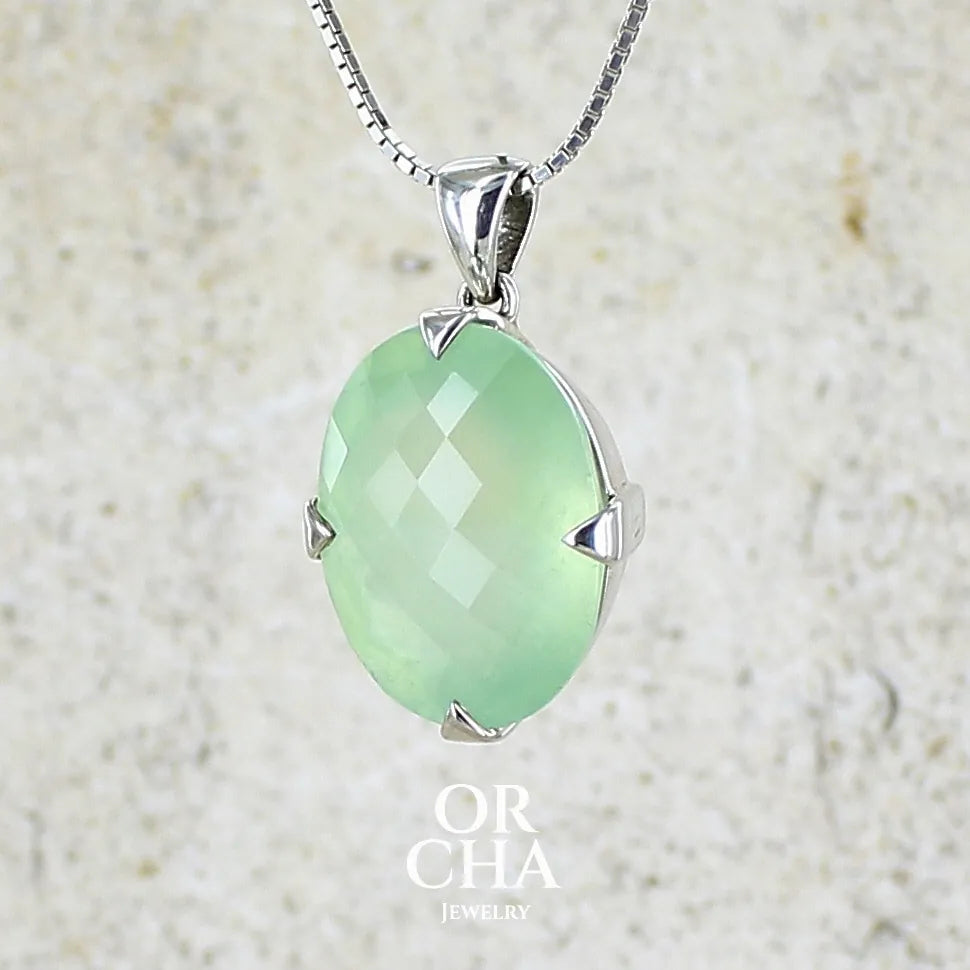 Pendentif ovale en argent massif, serti d'un cabochon facetté de préhnite de couleur verte jaune pastel. Pierre de qualité translucide comportant des inclusions. Bijoux unique par Orcha Jewelry