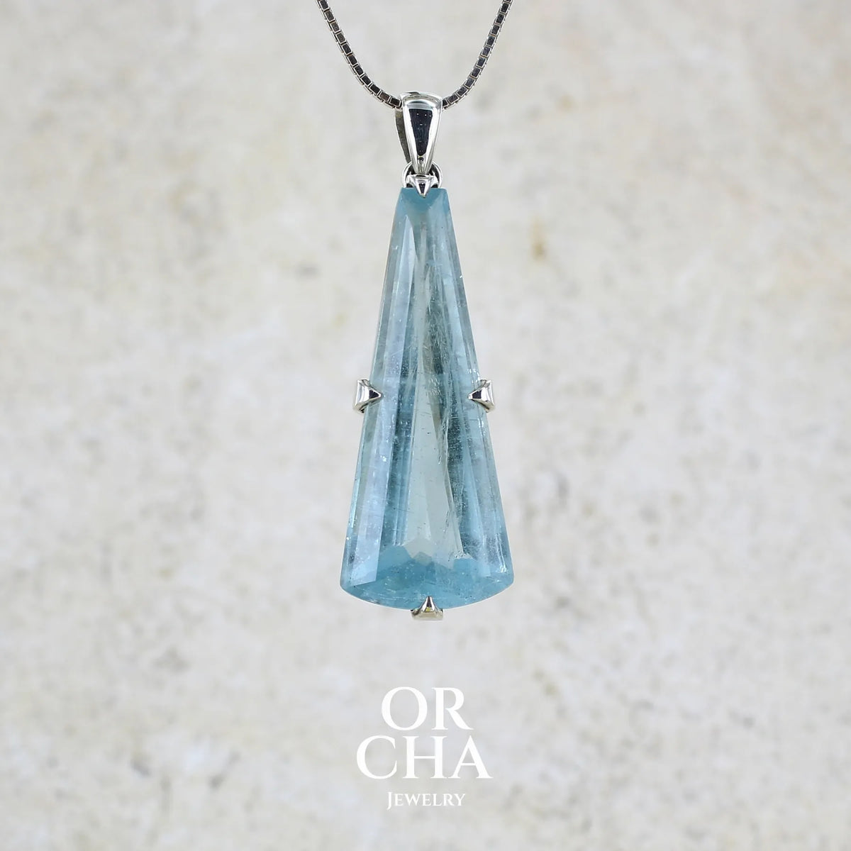 Pendentif en argent massif sertie d'une aigue marine taillée de 32 carats de couleur bleu clair profond et lumineux, pierre transparente avec inclusions. Pierre naturelle facettée de forme triangulaire allongé. Bijoux unique réalisée par Orchajewelry