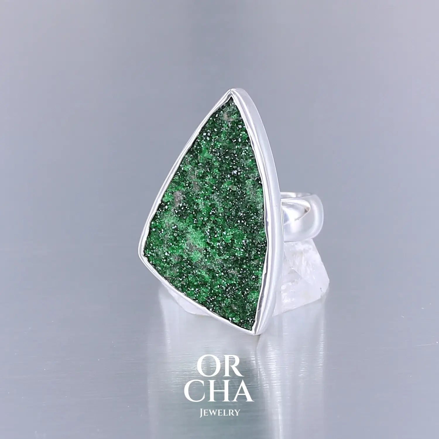 Bague en argent massif sertie d'un grenat Uvarovite brute. Pierre naturelle recouverte de cristaux scintillants de couleur verte. Bague réalisée en taille 58,5. Bijoux unique, éthique et durable présenté dans un coffret de notre marque, prêt à offrir. Livraison offerte, certificat d'authenticité, service client.