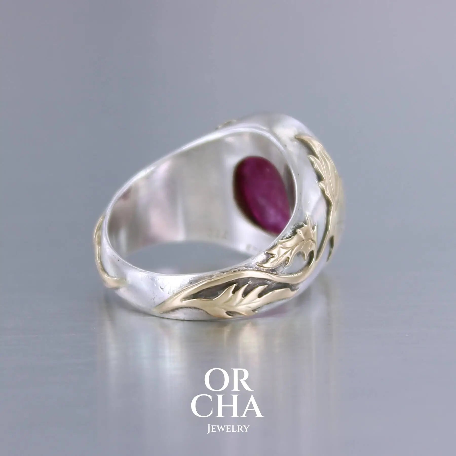 Bague chevalière pour femme en argent massif et or 18k où s'illustrent de chaque cotés de la bague des chardons. Cette bague est sertie d'un cabochon de rubis trapiche de couleur rouge rose. Pierre  translucide traitée au verre au plomb. Taille 60. Bijoux unique, éthique et durable présenté dans un coffret de notre marque, prêt à offrir. Livraison offerte, certificat d'authenticité, service client.