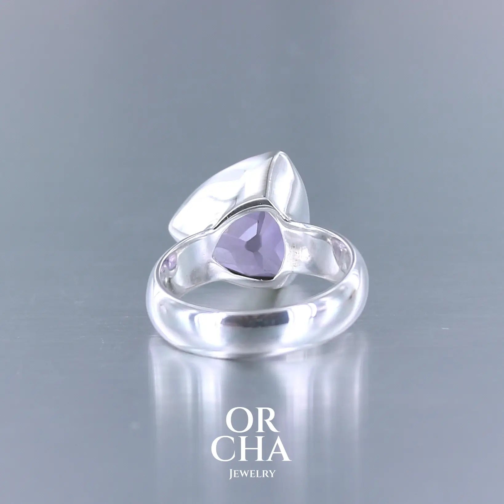 Bague cocktail pour femme en argent massif sertie d'une Améthyste. Pierre taillée trillion de qualité transparente, propre à l'oeil. Pierre naturelle de couleur violette clair gravée de motifs géométriques de fleur de vie. Tailles 58. Bijoux unique, éthique et durable présenté dans un coffret de notre marque, prêt à offrir. Livraison offerte, certificat d'authenticité, service client.