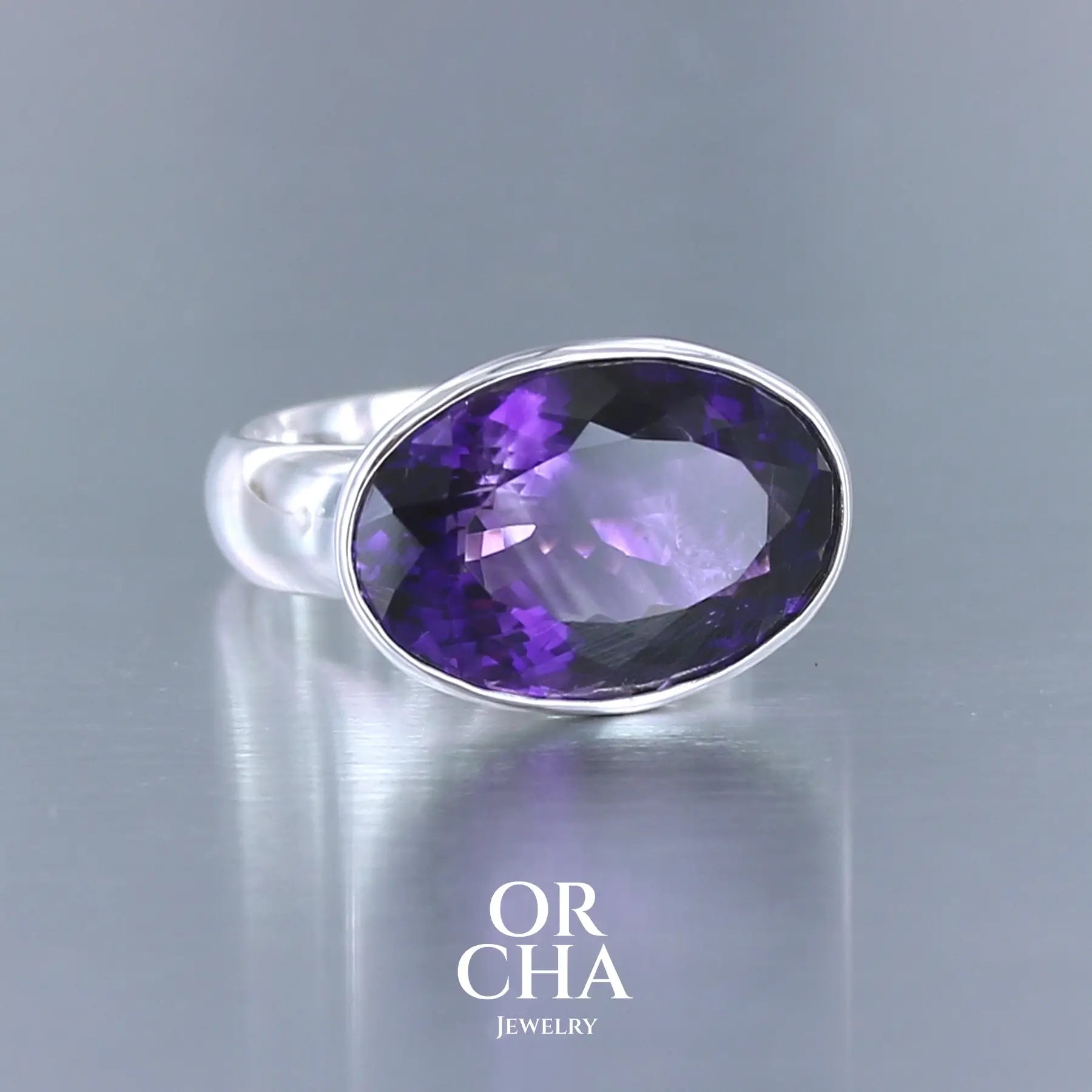 Bague cocktail pour femme en argent massif sertie d'une Améthyste. Pierre facettée de forme ovale de qualité transparente, propre à l'oeil. Pierre naturelle de couleur violette foncée aux légers reflets bleutés. Tailles 61. Bijoux unique, éthique et durable présenté dans un coffret de notre marque, prêt à offrir. Livraison offerte, certificat d'authenticité, service client.