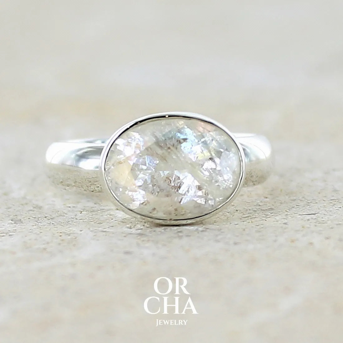Bague cocktail pour femme en argent massif 925 sertie d'une pierre de lune de Madagascar arc-en-ciel taillée de 3,58 carats. Pierre incolore aux reflets bleutés et arc-en-ciel. Pierre transparente avec inclusions. Bijoux unique réalisé en taille 56 par Orchajewelry