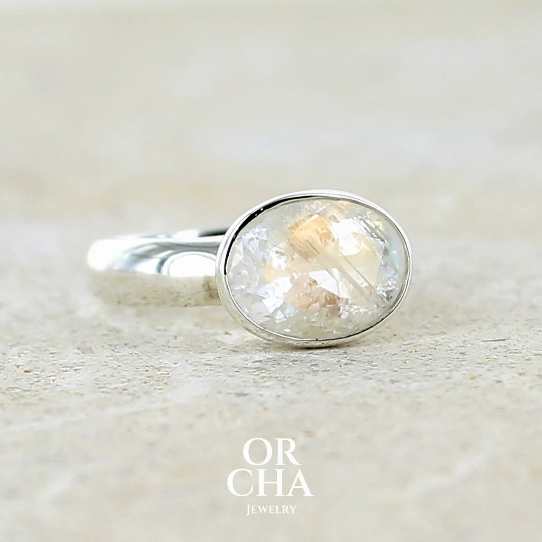 Bague cocktail pour femme en argent massif 925 sertie d'une pierre de lune de Madagascar arc-en-ciel taillée de 3,58 carats. Pierre incolore aux reflets bleutés et arc-en-ciel. Pierre transparente avec inclusions. Bijoux unique réalisé en taille 56 par Orchajewelry
