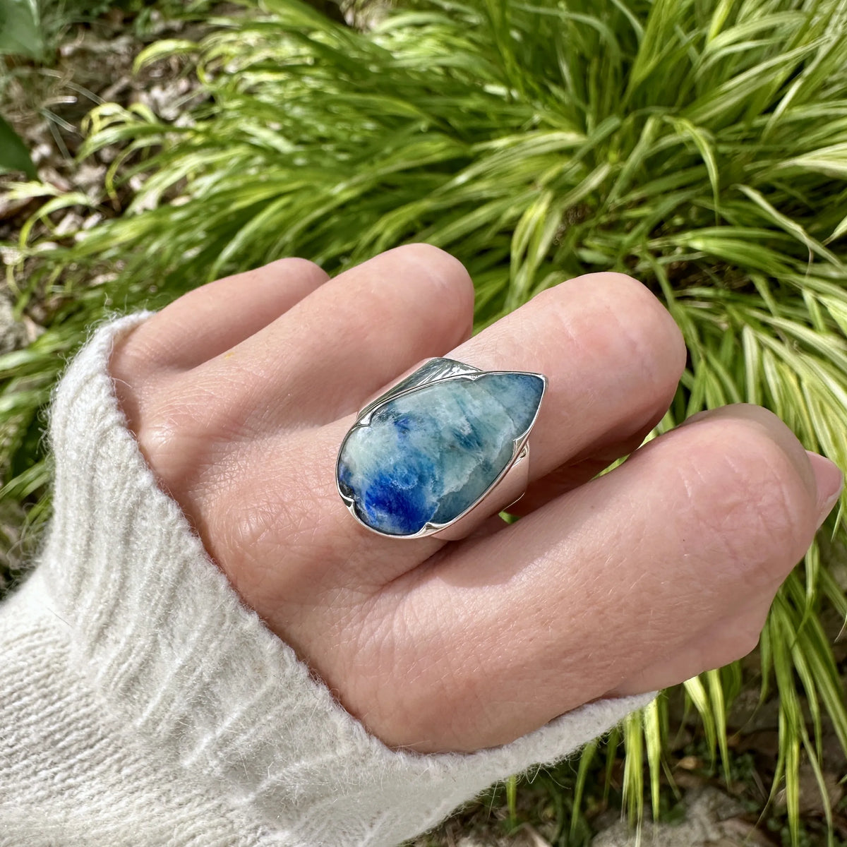 Bague pour femme en argent massif sertie d'un cabochon d'afghane de couleur bleu et bleu gris vert. Pierre taillée en forme de goutte de qualité opaque à inclusions (petites fissures) en surface, fréquente et admise sur ce type de pierre. Bijou unique réalisée en taille 58 par Orchajewelry