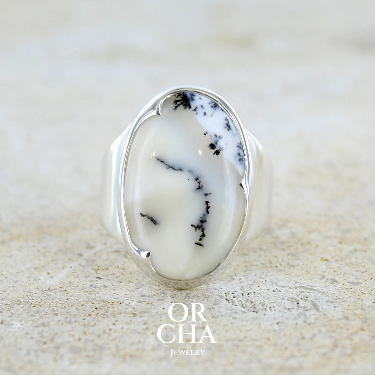 Bague pour femme en argent massif sertie d'un cabochon ovale d'agate dendritique de couleur blanc pur et noir. Pierre opaque translucide à inclusions paysages de dendrites de manganèse noires contrastées. Bijou unique réalisé en taille 54 par Orchajewelry