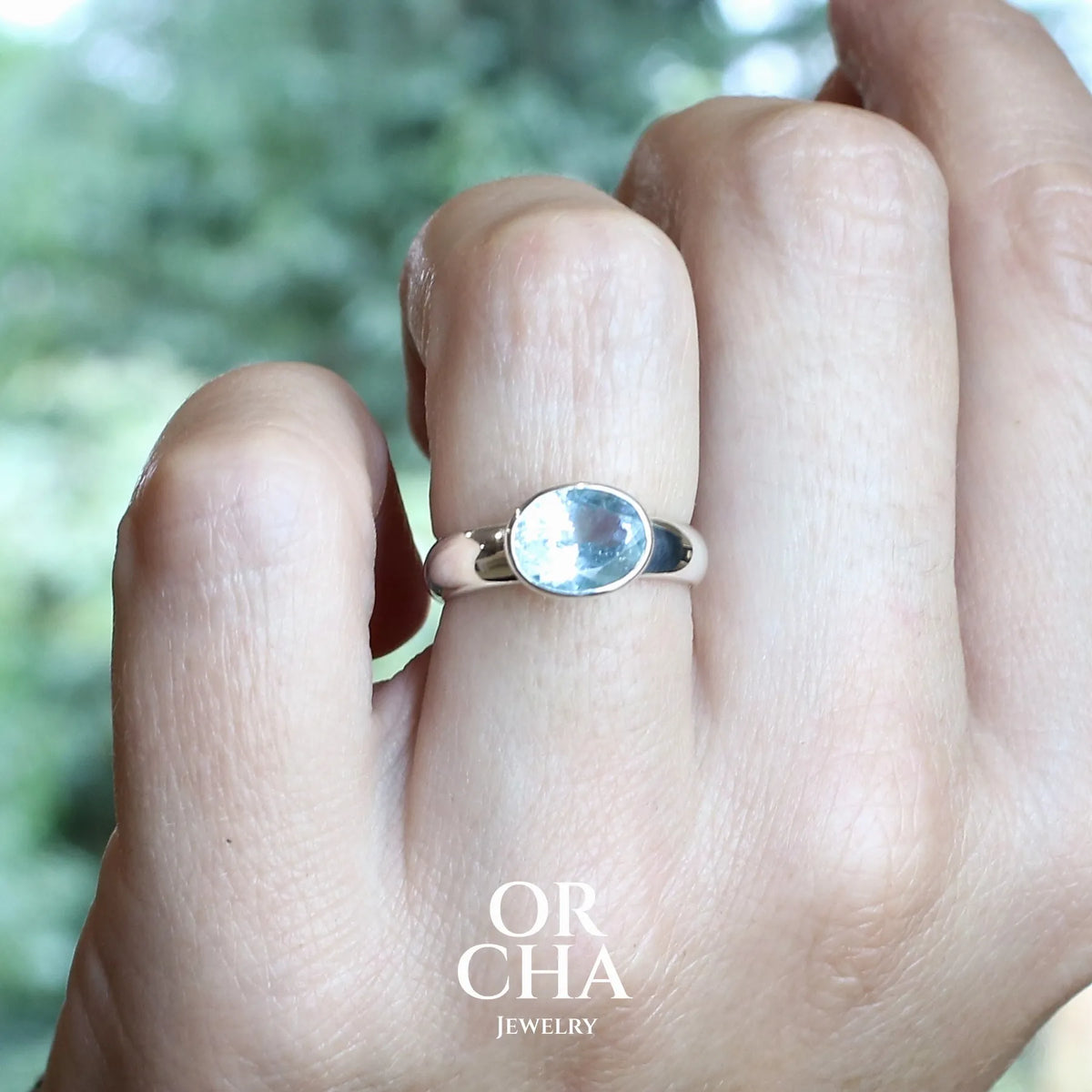 Bague pour femme en argent massif sertie d'une algue-marine de couleur bleu ciel lumineux et intense. Pierre naturelle de qualité transparente propre à l'oeil taillée de forme ovale. Bague unique réalisée en taille 52 par Orcha jewelry