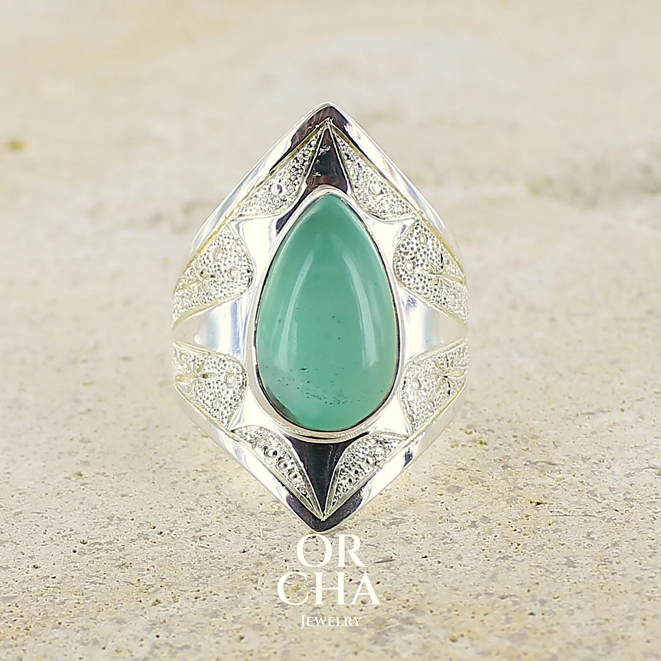 Bague étoile pour femme en argent massif, sertie d'un cabochon de calcédoine bleue verte. Pierre taillée de en forme de goutte. Pierre translucide. bijou unique réalisée en taille 59 par Orcha Jewelry