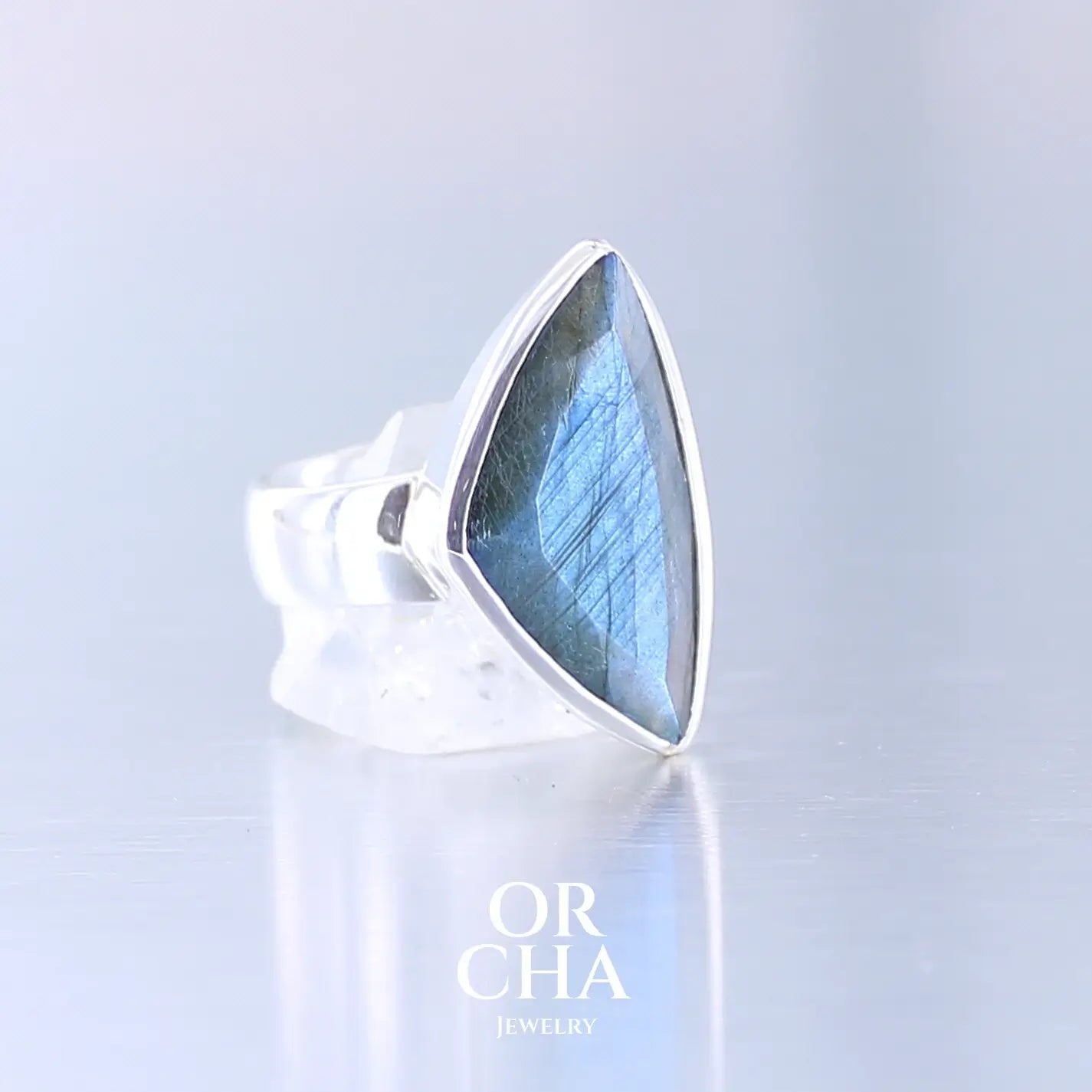 Bague pour femme en argent massif sertie d'une labradorite aux reflets bleus nuit. Pierre facettée naturelle translucide présentant des inclusions fréquents sur ce type de pierre. Taille 58,5. Bijoux unique, éthique et durable présenté dans un coffret de notre marque, prêt à offrir. Livraison offerte, certificat d'authenticité, service client.