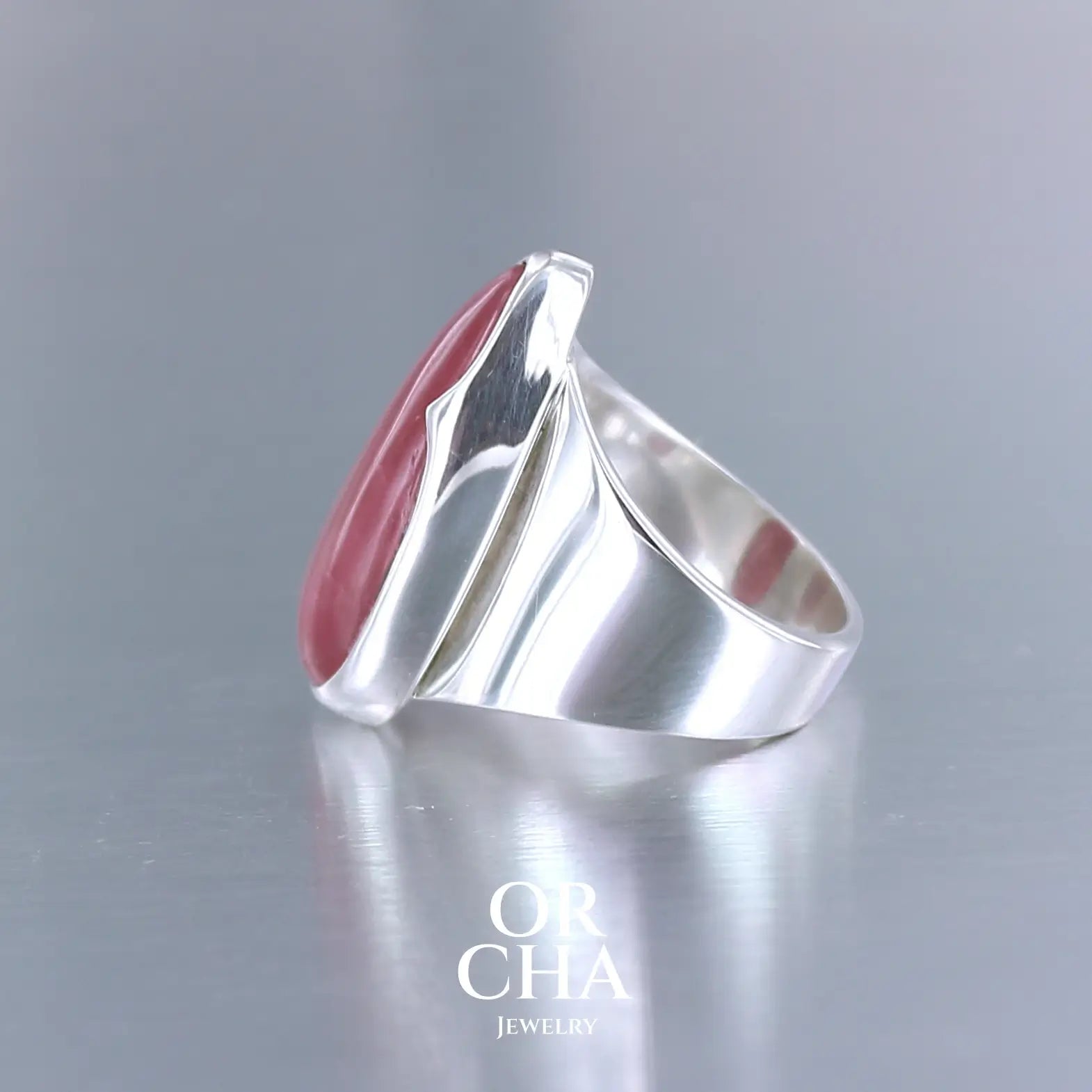Grande bague pour femme en argent massif sertie d'une Rhodonite. Pierre cabochon en forme de goutte, pierre naturelle de qualité rare de couleur rouge coquelicot. Pierre fine de qualité opaque. Taille 56. Bijoux unique, éthique et durable présenté dans un coffret de notre marque, prêt à offrir. Livraison offerte, certificat d'authenticité, service client.
