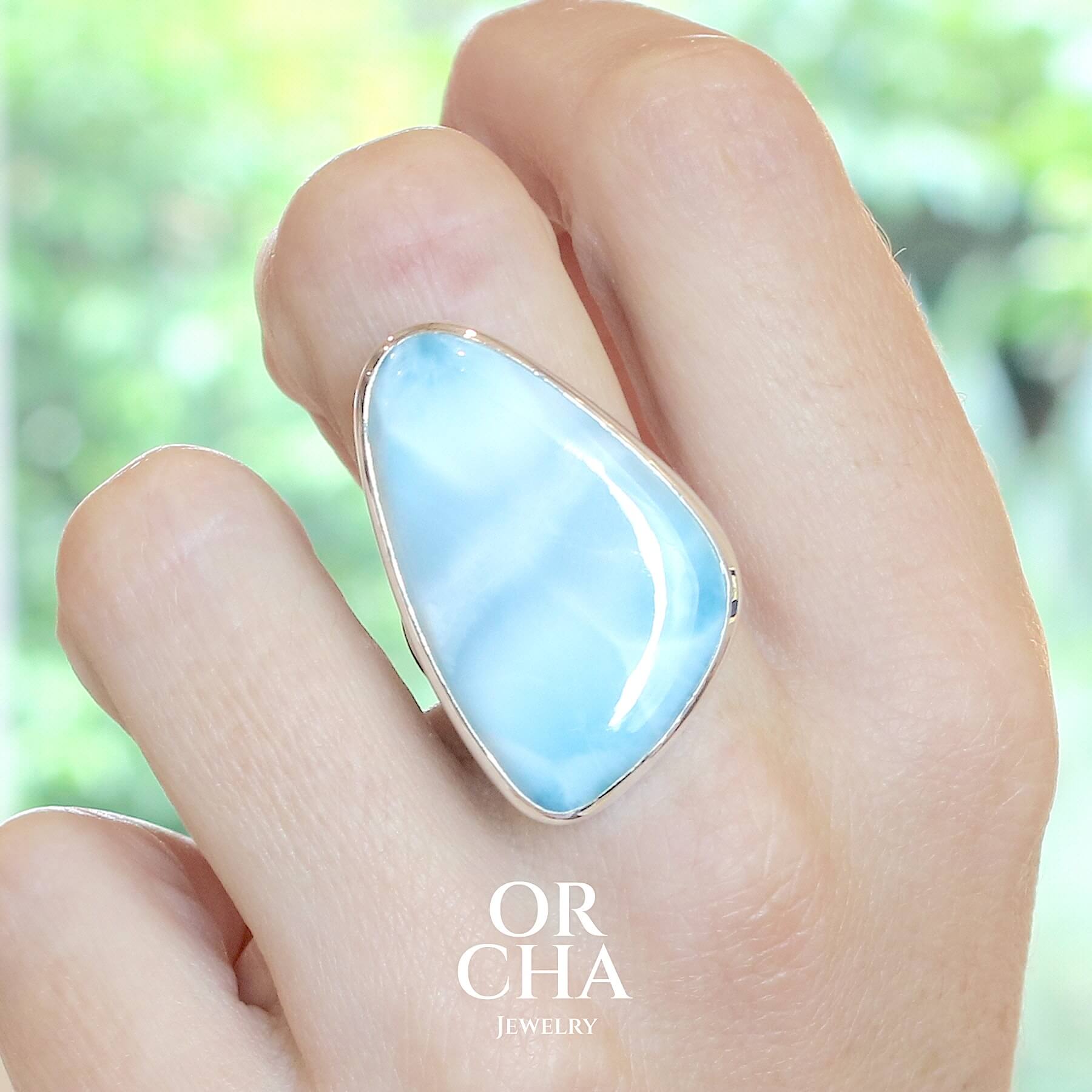 Grande bague pour femme en argent massif sertie d'un Larimar de République dominicaine. Cabochon de forme fantaisie, pierre naturelle de couleur bleu lagon présentant des marbrures blanches. Qualité translucide. Taille 58. Bijoux unique, éthique et durable présenté dans un coffret de notre marque, prêt à offrir. Livraison offerte, certificat d'authenticité, service client.