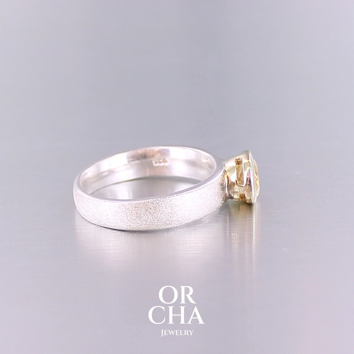 Bague anneau pour femme en argent massif et or sertie d'une Citrine. Pierre facettée de forme ovale, de qualité transparente, propre à l'oeil. Pierre naturelle de couleur jaune doré lumineux. Bijoux unique, éthique et durable présenté dans un coffret de notre marque, prêt à offrir. Livraison offerte, certificat d'authenticité, service client.