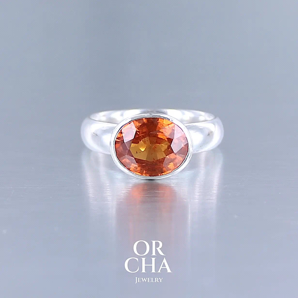 Bague cocktail pour femme en argent massif sertie d'un Grenat Spessartite. Pierre facettée de forme ovale de qualité transparente, propre à l'oeil. Pierre naturelle de couleur orange intense, ce Grenat est également appelé Grenat "Fanta" en rapport à la couleur saturé du célèbre soda. Tailles 58.5. Bijoux unique, éthique et durable présenté dans un coffret de notre marque, prêt à offrir. Livraison offerte, certificat d'authenticité, service client.