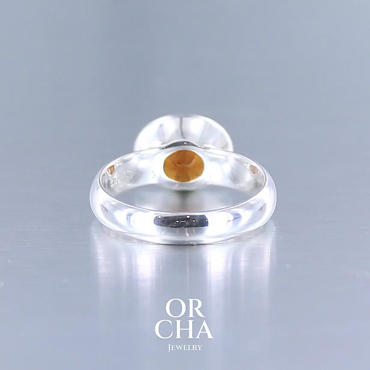 Vue arrière d'une bague cocktail pour femme en argent massif sertie d'un Grenat Spessartite. Pierre facettée de forme ovale de qualité transparente, propre à l'oeil. Pierre naturelle de couleur orange intense, ce Grenat est également appelé Grenat "Fanta" en rapport à la couleur saturé du célèbre soda. Tailles 58.5. Bijoux unique, éthique et durable présenté dans un coffret de notre marque, prêt à offrir. Livraison offerte, certificat d'authenticité, service client.