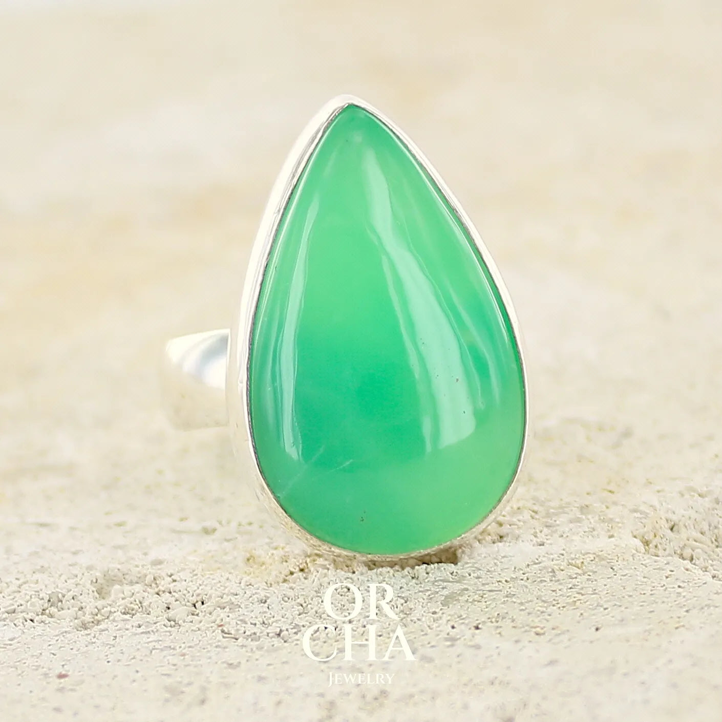 Bague pour femme en argent massif, sertie d'un cabochon de Chrysoprase. Pierre taillée en forme de goutte de qualité opaque. Bijoux unique réalisé en taille 58 par Orcha Jewelry