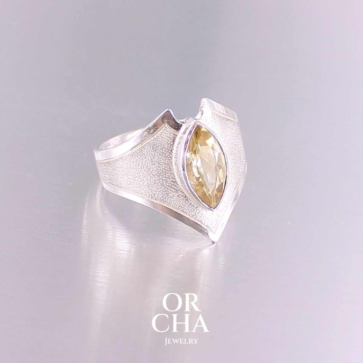 Bague contemporaine en forme pour femme en argent massif sertie d'une Citrine. Pierre facettée en forme de marquise de qualité transparente, propre à l'oeil. Pierre naturelle de couleur jaune doré lumineux. Bijoux unique, éthique et durable présenté dans un coffret de notre marque, prêt à offrir. Livraison offerte, certificat d'authenticité, service client.