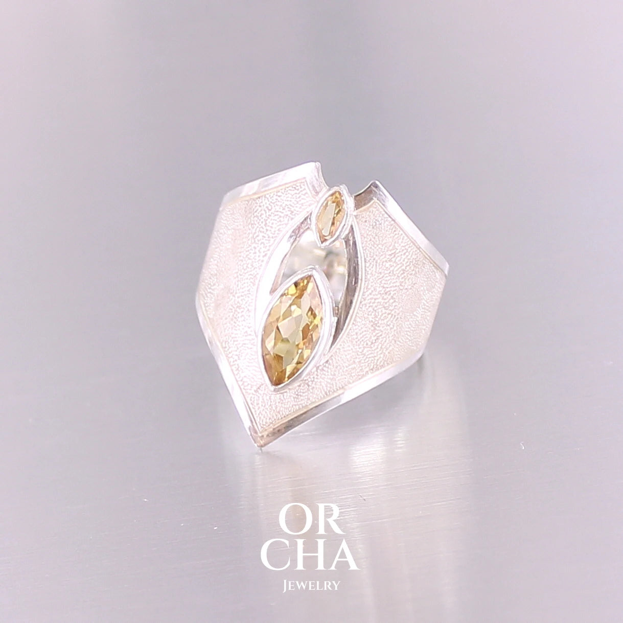 Grande bague contemporaine pour femme en argent massif sertie de Citrines. Pierre facettée en forme de marquise de qualité transparente, propre à l'oeil. Pierre naturelle de couleur jaune doré lumineux. Bijoux unique, éthique et durable présenté dans un coffret de notre marque, prêt à offrir. Livraison offerte, certificat d'authenticité, service client.