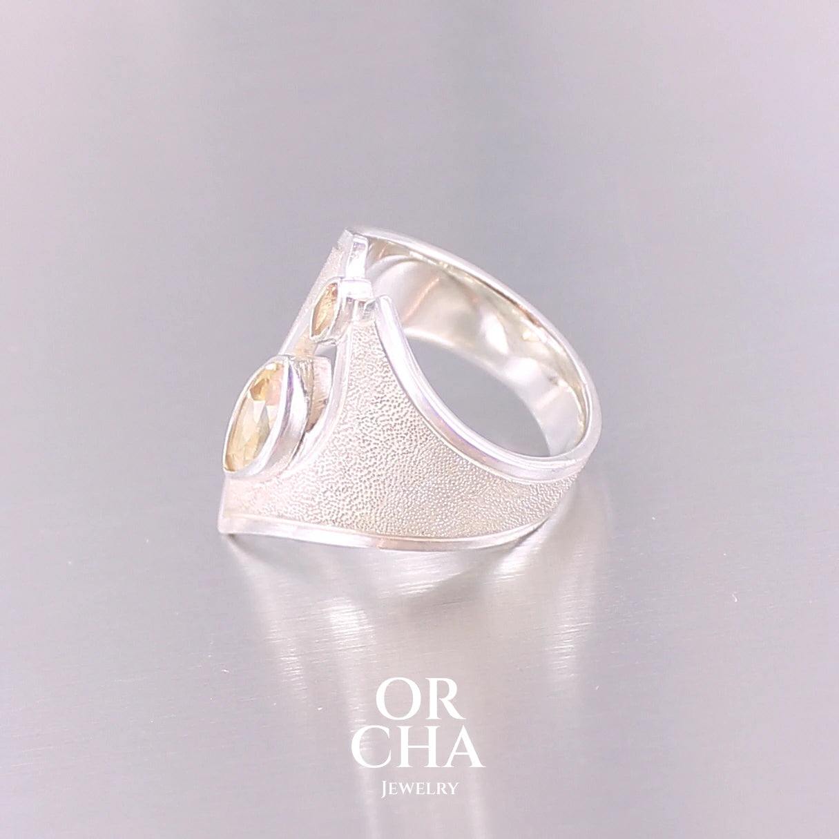 Grande bague contemporaine pour femme en argent massif sertie de Citrines. Pierre facettée en forme de marquise de qualité transparente, propre à l'oeil. Pierre naturelle de couleur jaune doré lumineux. Bijoux unique, éthique et durable présenté dans un coffret de notre marque, prêt à offrir. Livraison offerte, certificat d'authenticité, service client.
