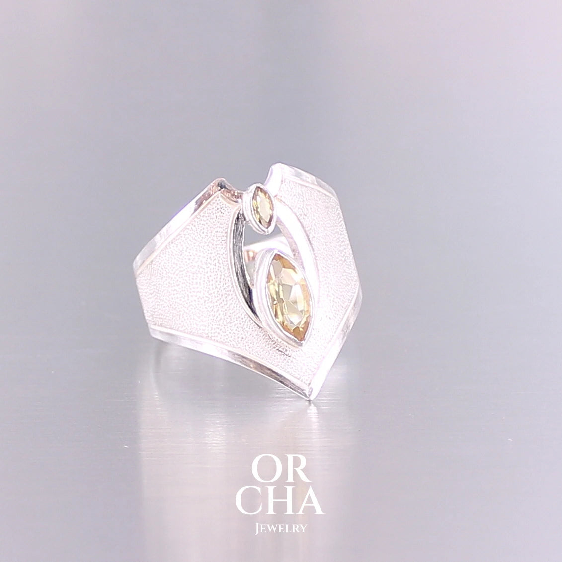 Grande bague contemporaine pour femme en argent massif sertie de Citrines. Pierre facettée en forme de marquise de qualité transparente, propre à l'oeil. Pierre naturelle de couleur jaune doré lumineux. Bijoux unique, éthique et durable présenté dans un coffret de notre marque, prêt à offrir. Livraison offerte, certificat d'authenticité, service client.