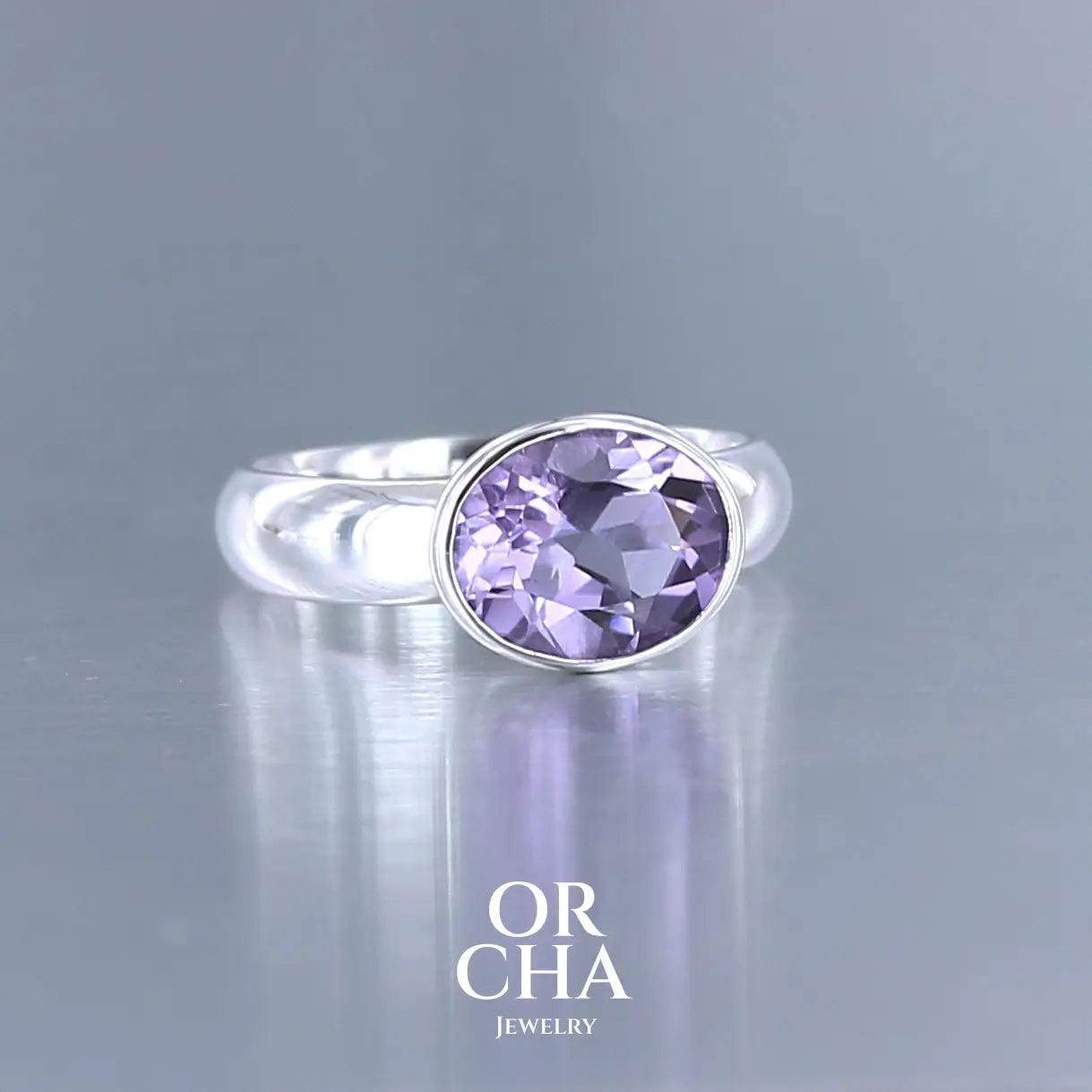 Bague minimaliste pour femme en argent massif sertie d'une Améthyste. Pierre facettée de forme ovale de qualité transparente, propre à l'oeil. Pierre naturelle de couleur violette clair type rose de France. Tailles 58. Bijoux unique, éthique et durable présenté dans un coffret de notre marque, prêt à offrir. Livraison offerte, certificat d'authenticité, service client.