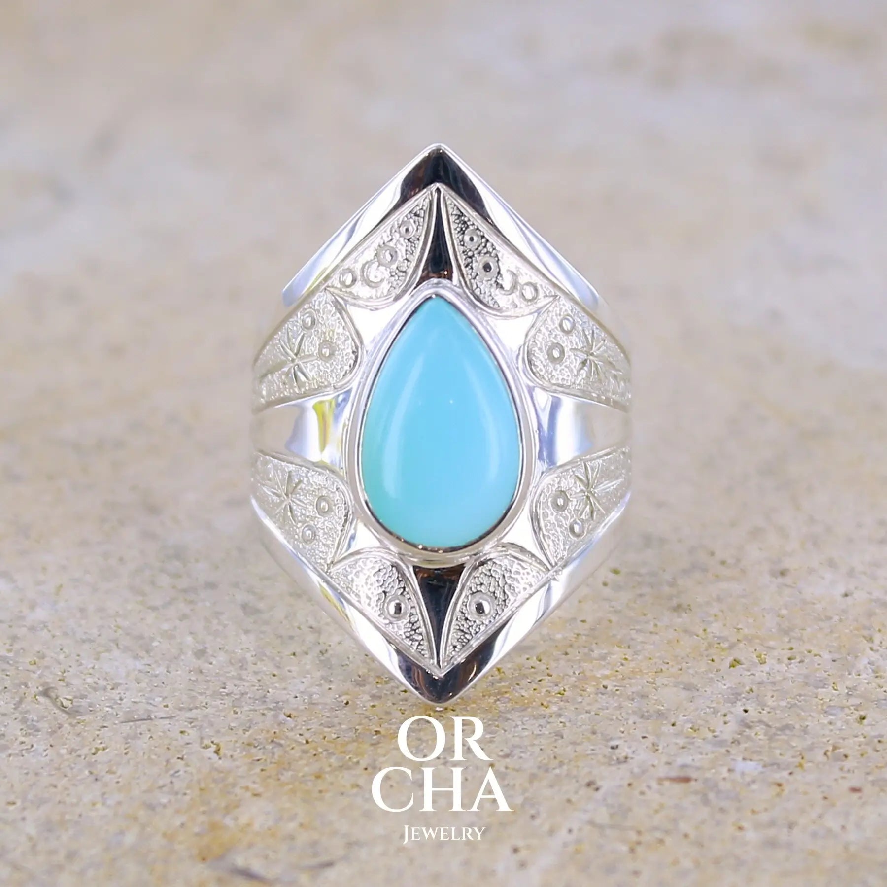 Bague pour femme en argent massif sculptées d'étoiles et autres corps célestes sertie d'une Opale bleue du Pérou. Pierre cabochon en forme de goutte, pierre naturelle de couleur bleu ciel ciel, bleu turquoise. Pierre naturelle de qualité opaque. Taille 51. Bijoux unique, éthique et durable présenté dans un coffret de notre marque, prêt à offrir. Livraison offerte, certificat d'authenticité, service client.