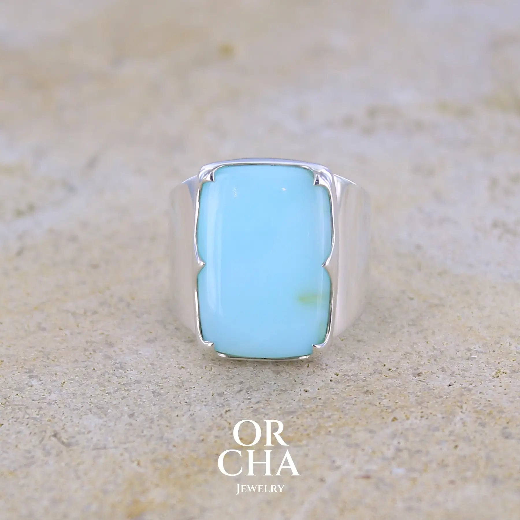 Bague pour femme en argent massif sculptées d'étoiles et autres corps célestes sertie d'une Opale bleue du Pérou. Pierre cabochon en forme de rectangle, pierre naturelle de couleur bleu ciel ciel, bleu turquoise. Pierre naturelle de qualité opaque. Taille 58. Bijoux unique, éthique et durable présenté dans un coffret de notre marque, prêt à offrir. Livraison offerte, certificat d'authenticité, service client.