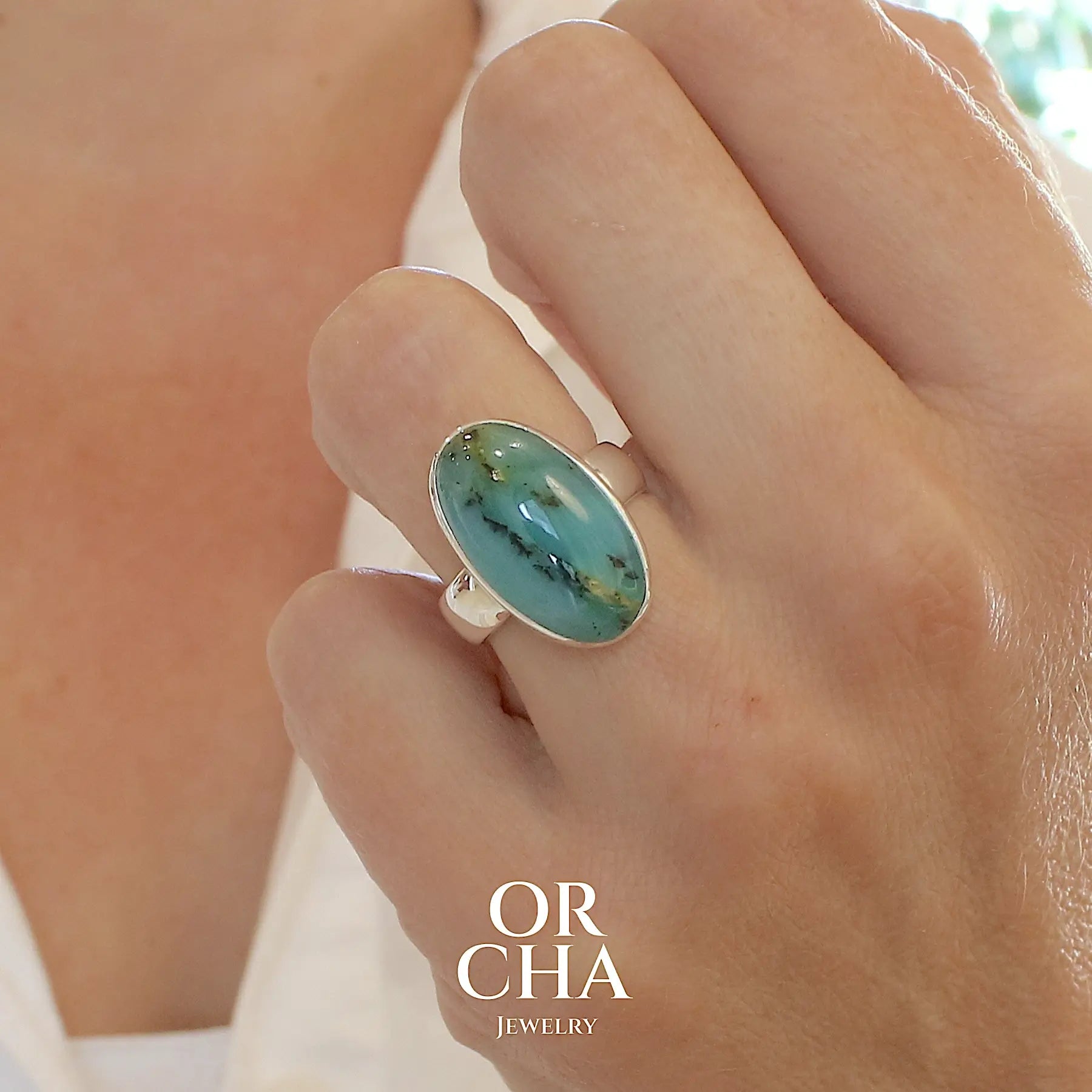 Bague en argent massif, sertie d'un cabochon ovale d'opale bleue du Pérou de couleur bleu foncé à inclusions de dendrites paysages noires et de roche mère jaune. Pierre naturelle opaque et translucide. Bijoux unique réalisé en taille 52 par Orcha jewelry