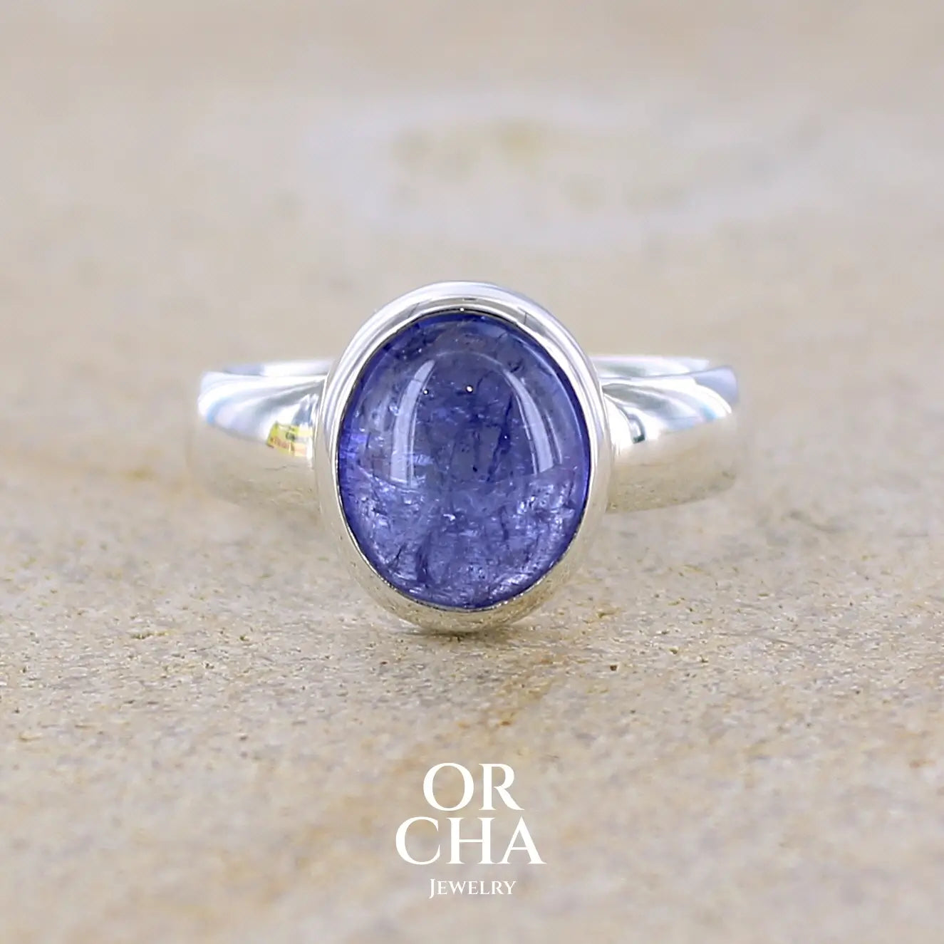 Bague anneau pour femme en argent massif, sertie d'un cabochon de tanzanite bleu lavande. Pierre de forme ovale. Pierre transparente comportant des inclusions. Taille 56. Bijoux unique, éthique et durable présenté dans un coffret de notre marque, prêt à offrir. Livraison offerte, certificat d'authenticité, service client.