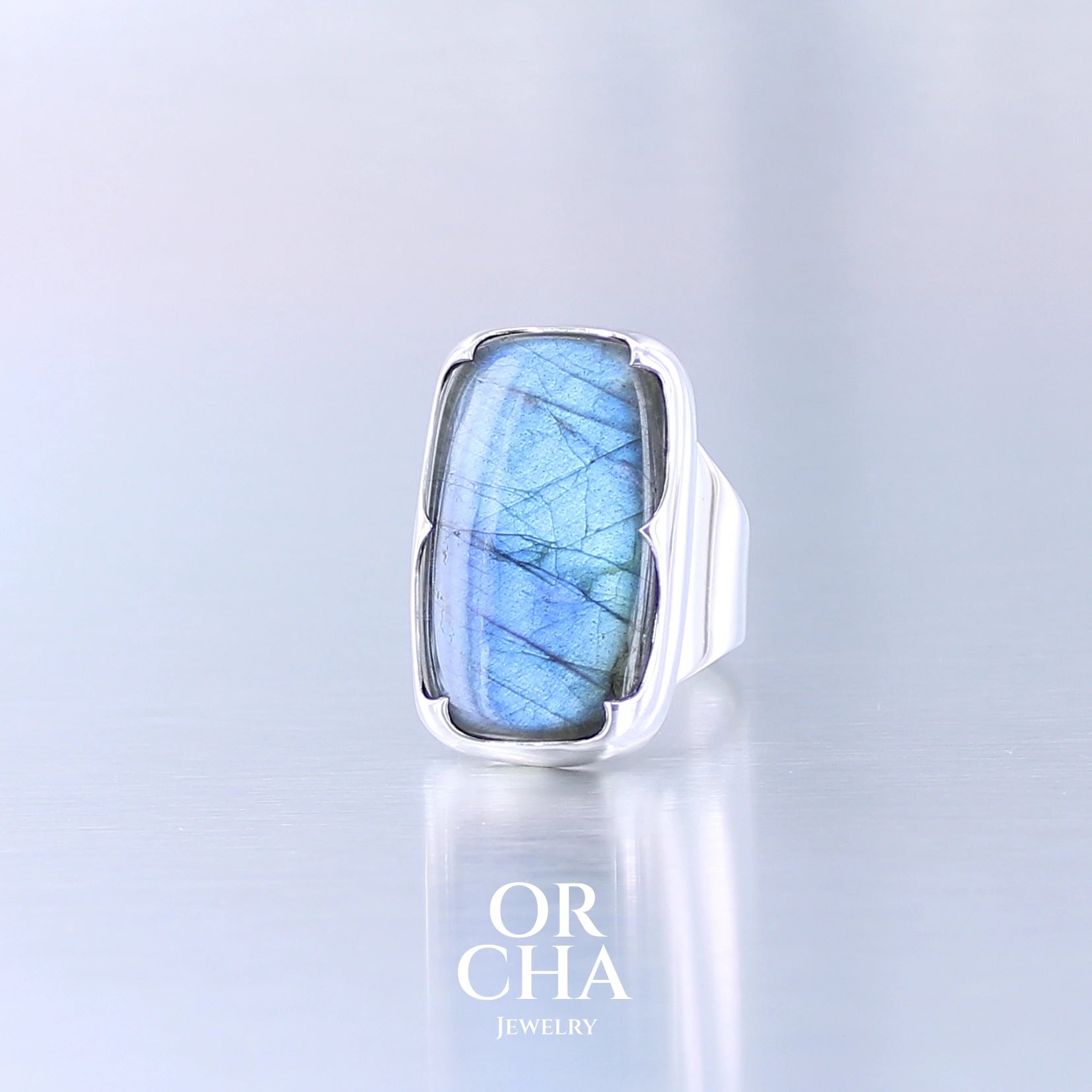 Bague unique pour femme en argent massif sertie d'une labradorite aux reflets bleus selon la lumière. Pierre cabochon naturelle translucide présentant des inclusions fréquents sur ce type de pierre. Taille 56. Bijoux unique, éthique et durable présenté dans un coffret de notre marque, prêt à offrir. Livraison offerte, certificat d'authenticité, service client.