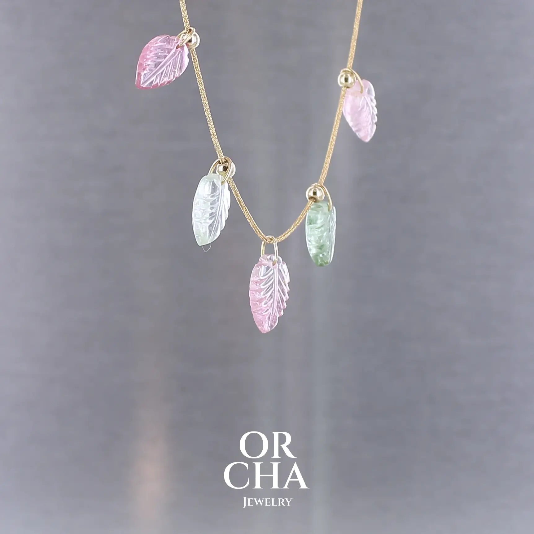 Collier pour femme orné de tourmalines roses et vertes sculptées à la main en 3 dimensions en forme de feuilles serties en or 18k. Les breloques sont montées sur un collier corde doré scintillant, les apprêts utilisé sont en Gold filled ( or laminé ). Longueur ajustable de 40 cm à 45 cm. Bijoux unique, éthique et durable présenté dans un coffret de notre marque, prêt à offrir. Livraison offerte, certificat d'authenticité, service client.